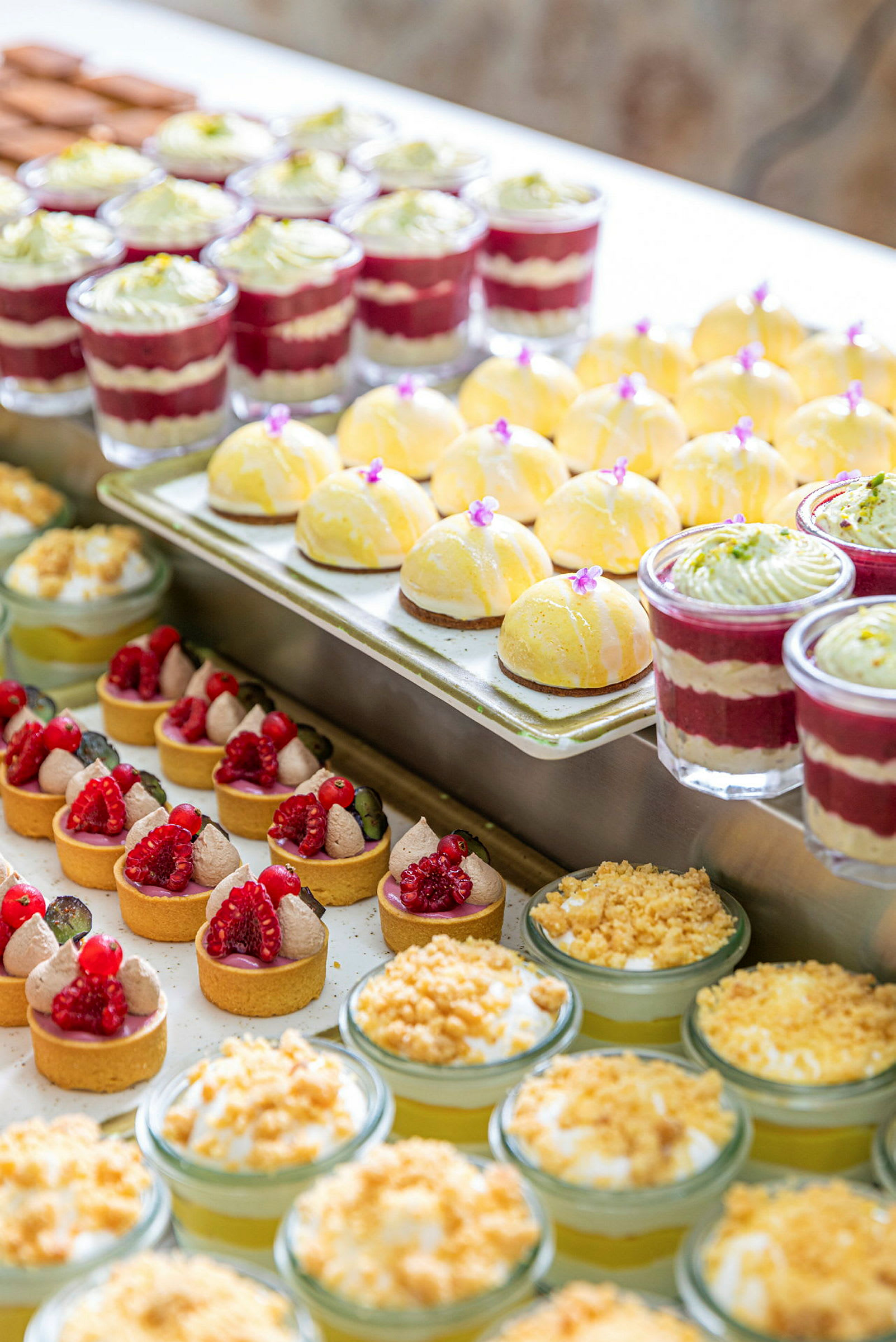 En rekke forskjellige desserter, inkludert små bakverk og glass med kremet topping. (AI-generert tekst)