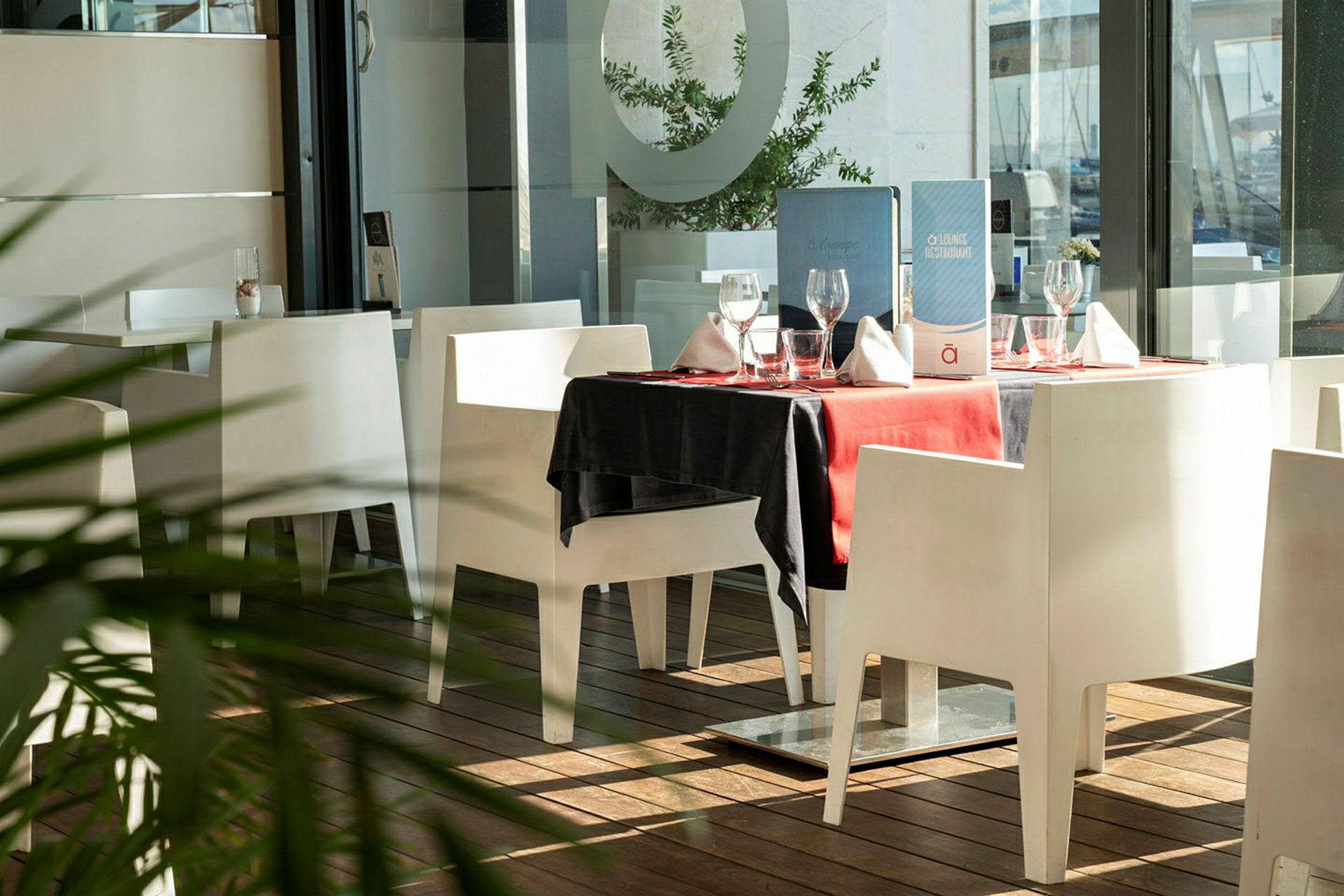 Et bord i en restaurant med hvit innredning og rød duk. (AI-generert tekst)