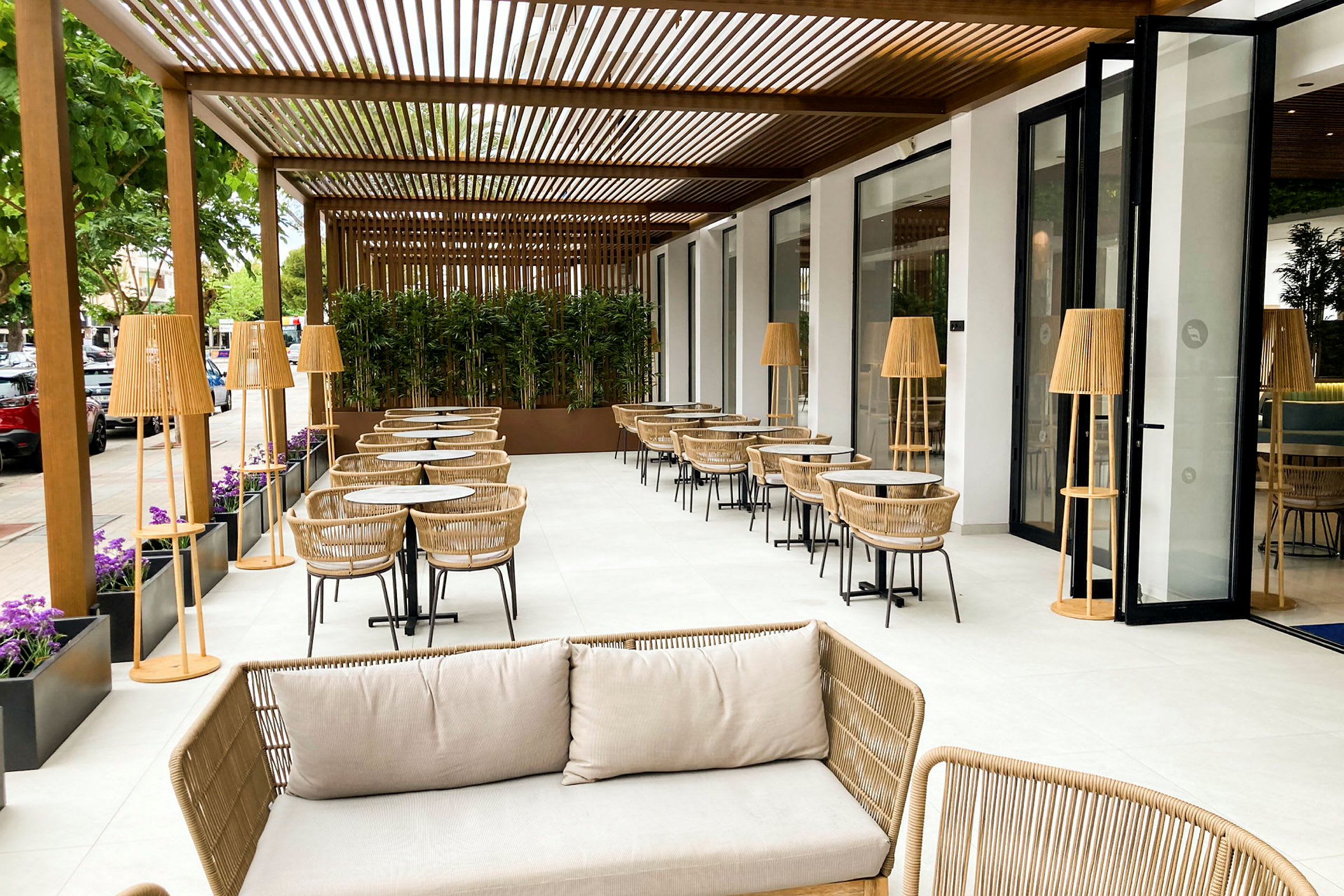 Utendørs terrasse med sitteplasser, bord og rottingmøbler. (AI-generert tekst)
