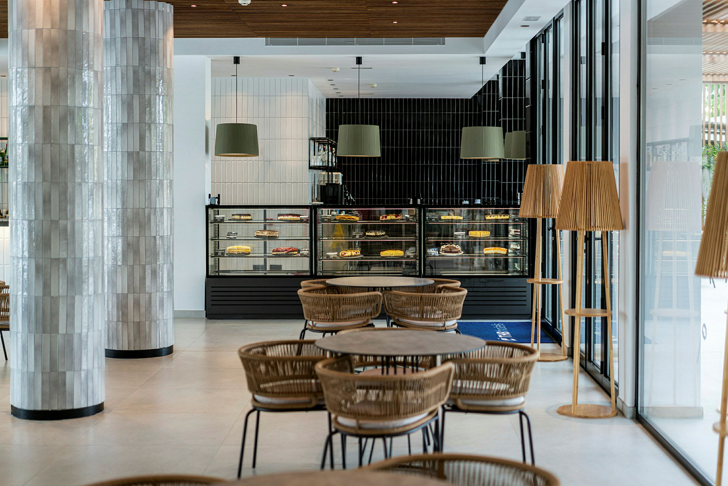 En moderne kafé med sitteplasser og utstillingsdisker fylt med kaker og bakverk. (AI-generert tekst)