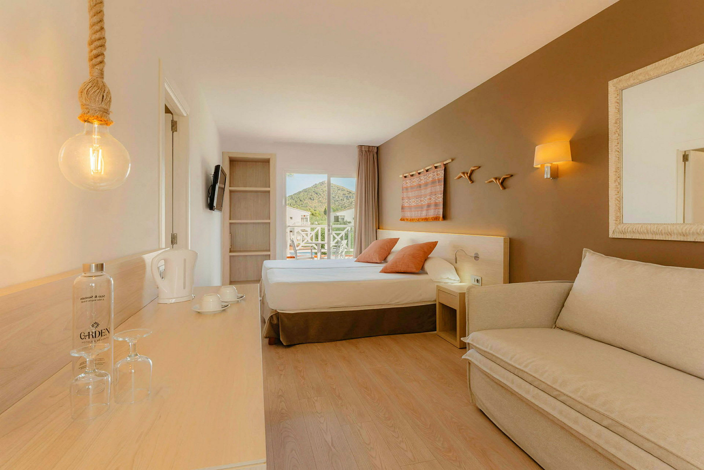 Et hotellrom med en seng, en sofa og en arbeidsflate. (AI-generert tekst)