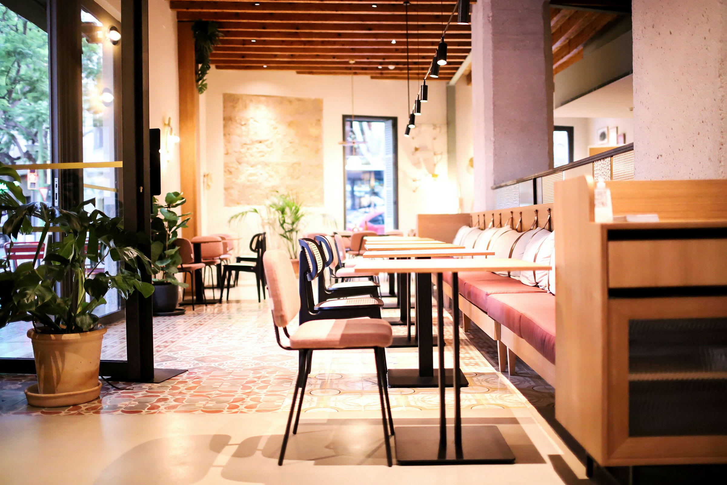 En lyst og moderne innredet kafé, med tremøbler og planter som dekorasjon. (AI-generert tekst)