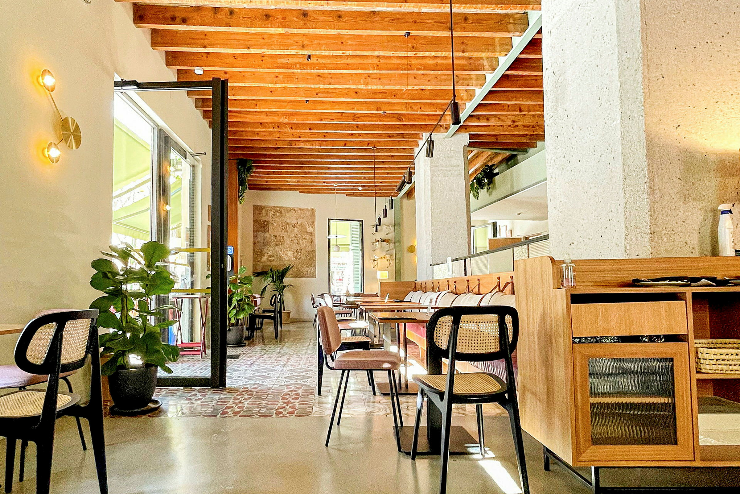 Et moderne kafé med trebjelker i taket, naturfarger og stilfull innredning. (AI-generert tekst)