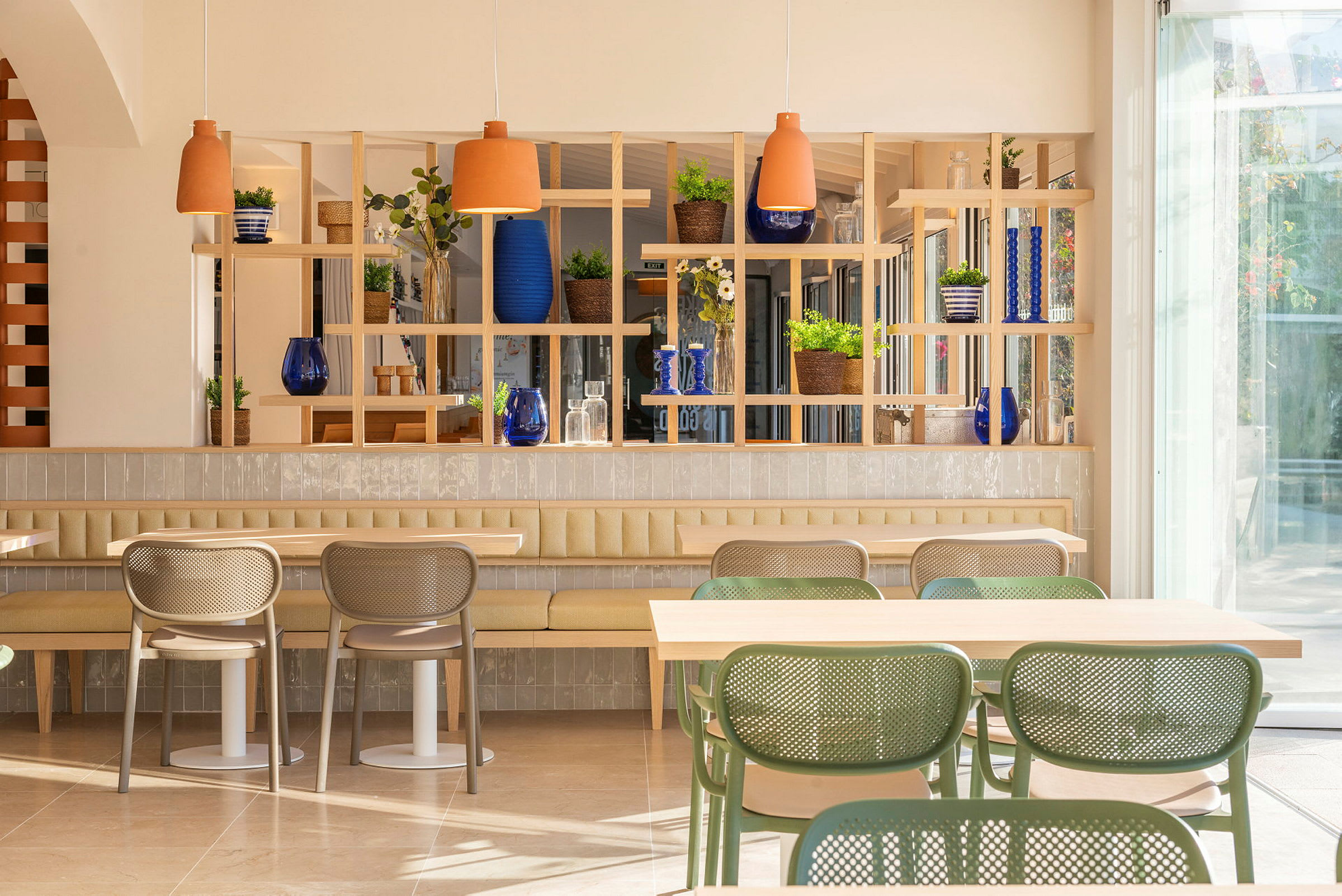 Et lyst og moderne kafé med stilfulle møbler og grønne planter. (AI-generert tekst)