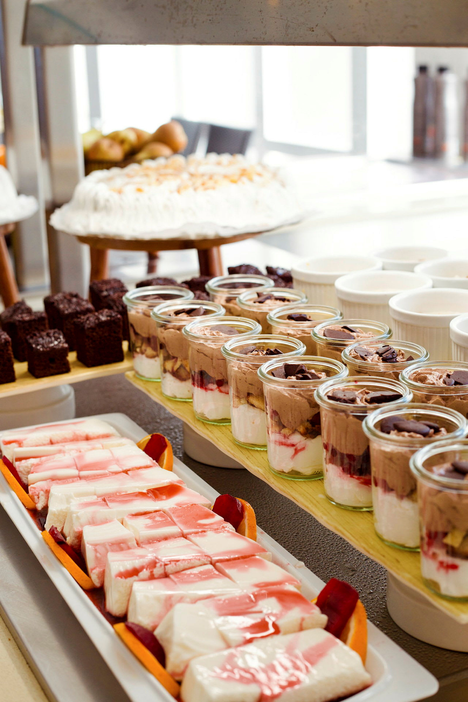Bilde av et dessertbord med ulike desserter som kake, bakverk og glass med mousse. (AI-generert tekst)