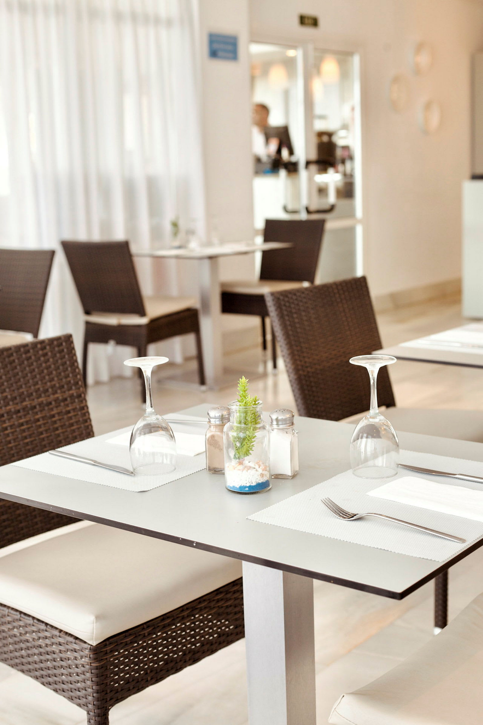 Et dekket bord med stoler i en restaurant. (AI-generert tekst)