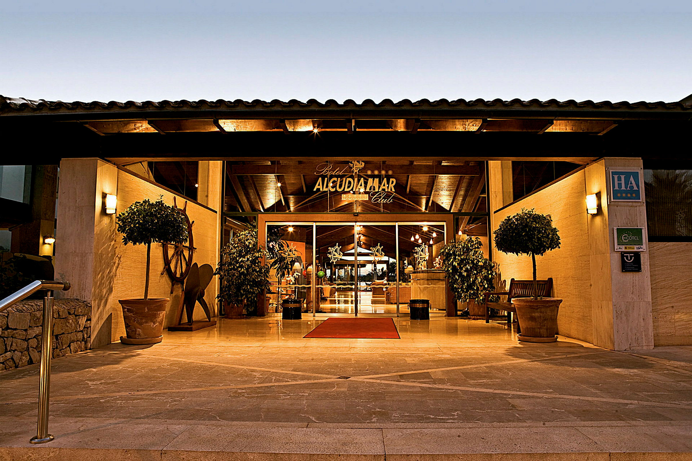 Inngang til Alcudia Mar Club Hotel på kveldstid. (AI-generert tekst)