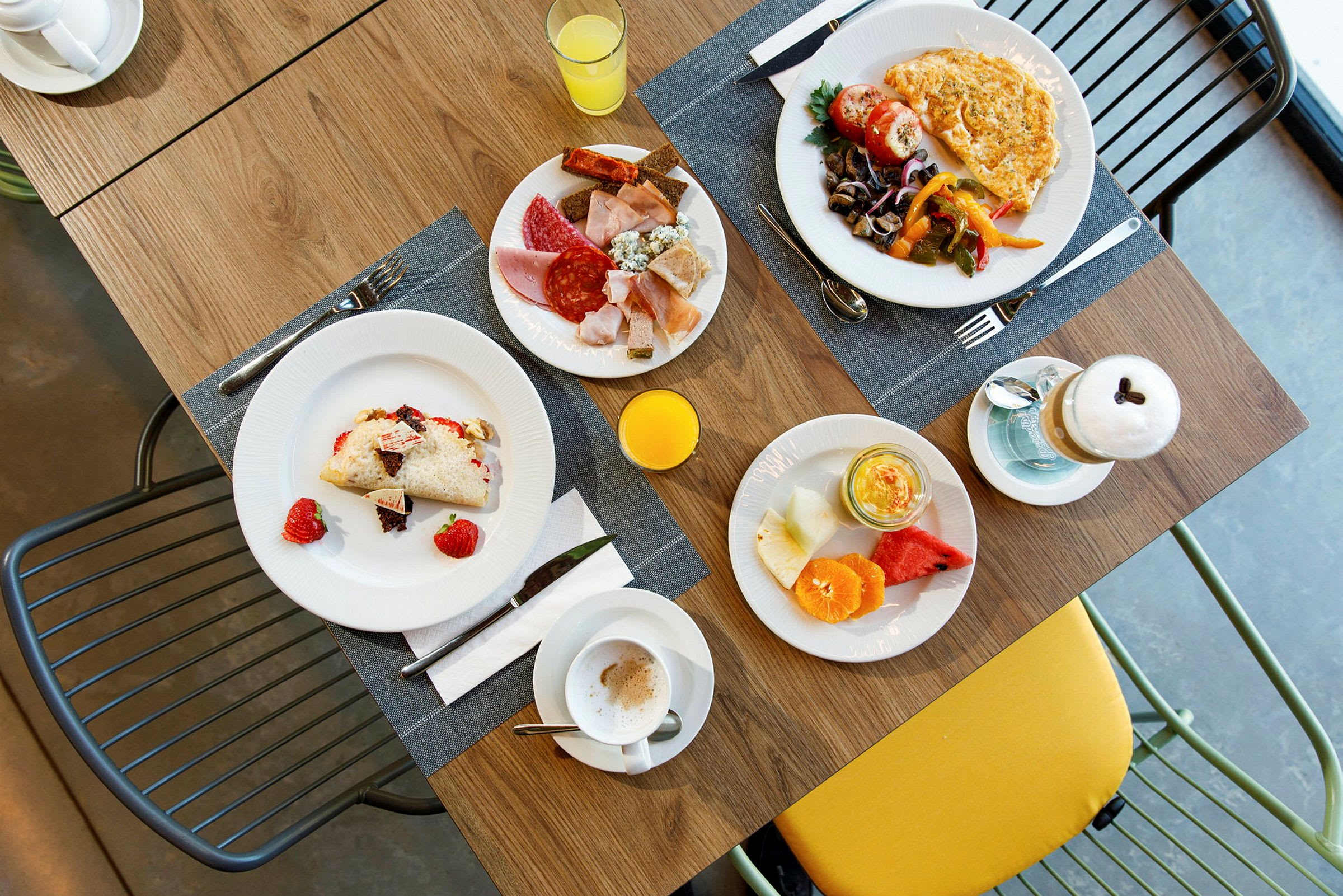 En frokost som er satt frem på et bord med flere ulike retter og drikkevarer. (AI-generert tekst)