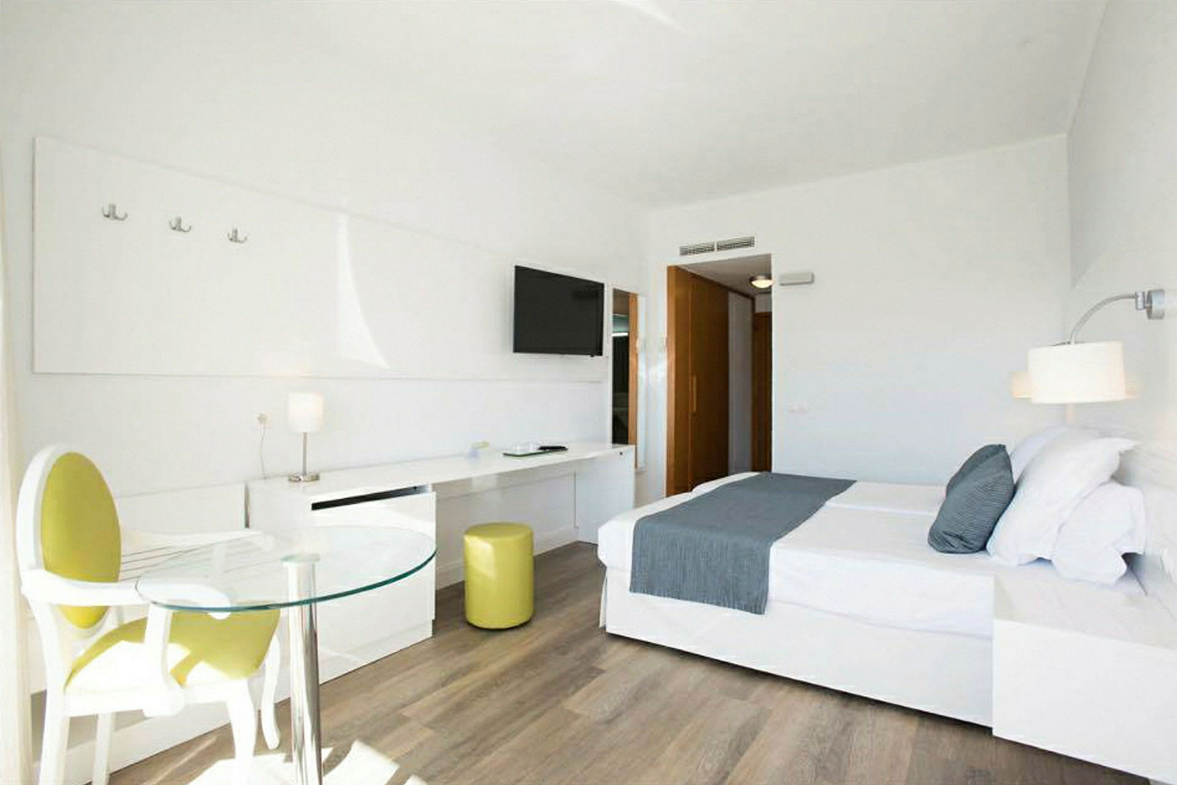 Moderne og lyst hotellrom med en stor seng og sittegruppe. (AI-generert tekst)