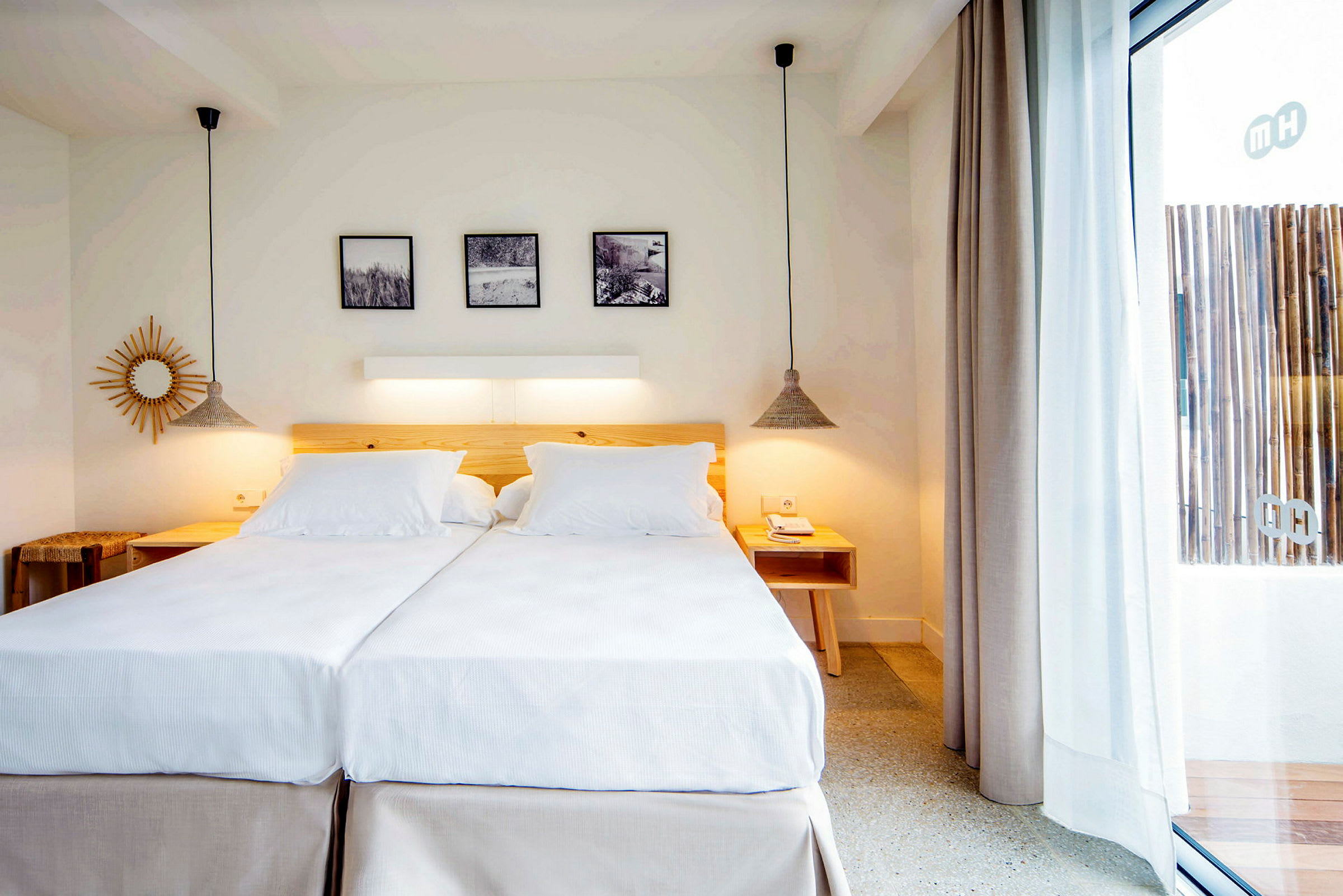 Et lyst og stilfullt innredet hotellrom med to enkeltsenger satt sammen til en dobbeltseng, tredetaljer og moderne dekor. (AI-generert tekst)