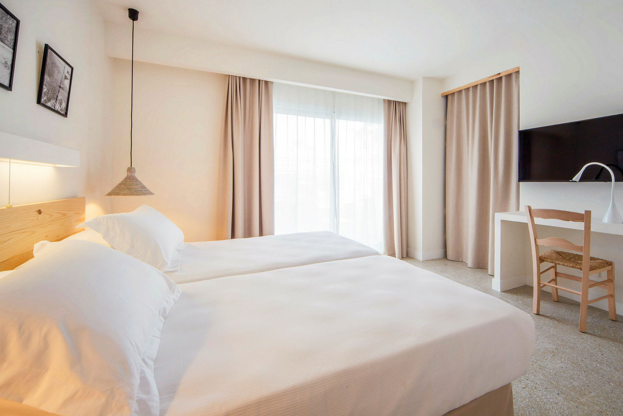 Moderne hotellrom med to enkeltsenger, skrivebord og TV. (AI-generert tekst)