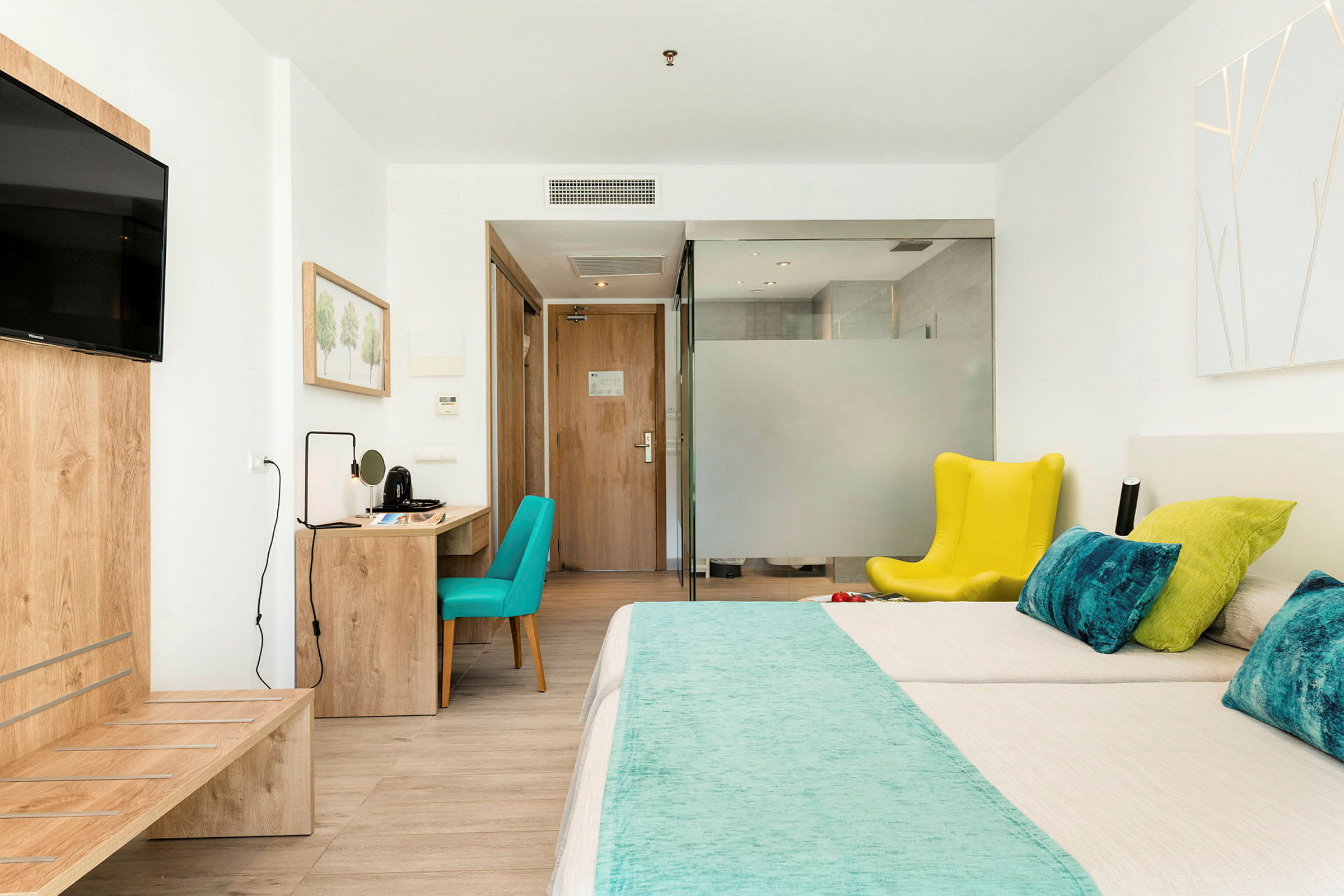 Hotellrom med seng, skrivebord og sitteplass. (AI-generert tekst)