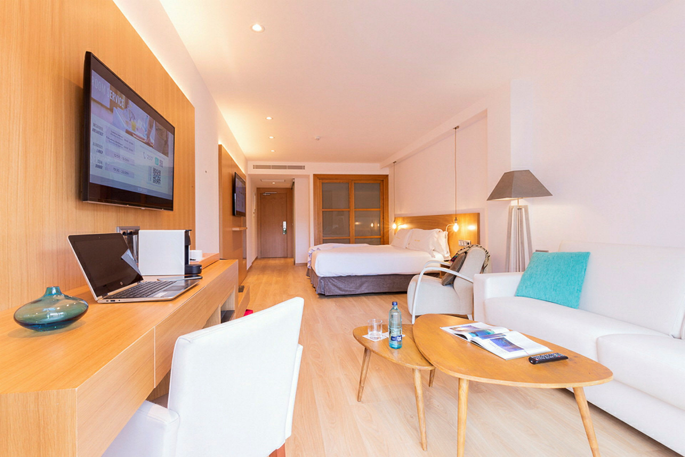 Et elegant hotellrom med en stor seng, skrivebord, sittegruppe og moderne innredning. (AI-generert tekst)