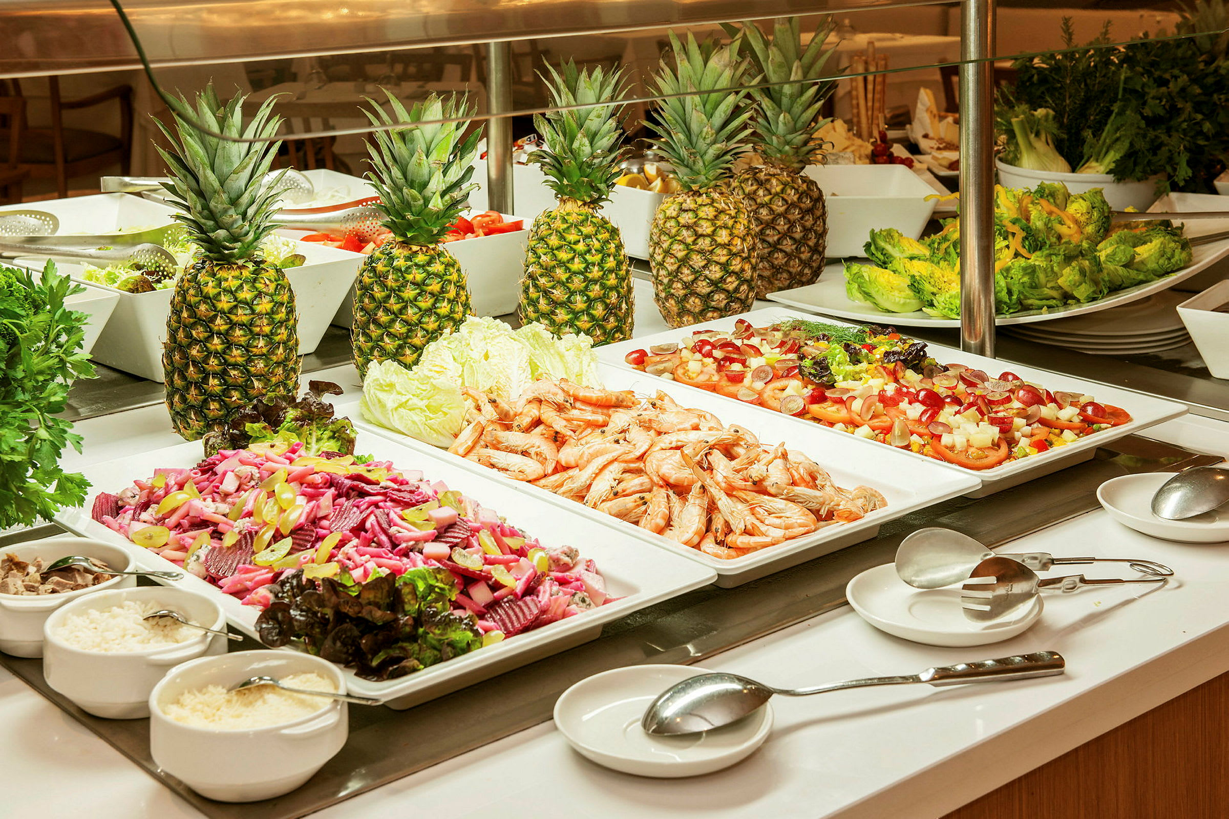 Buffetbord med salat, reker og ananas. (AI-generert tekst)