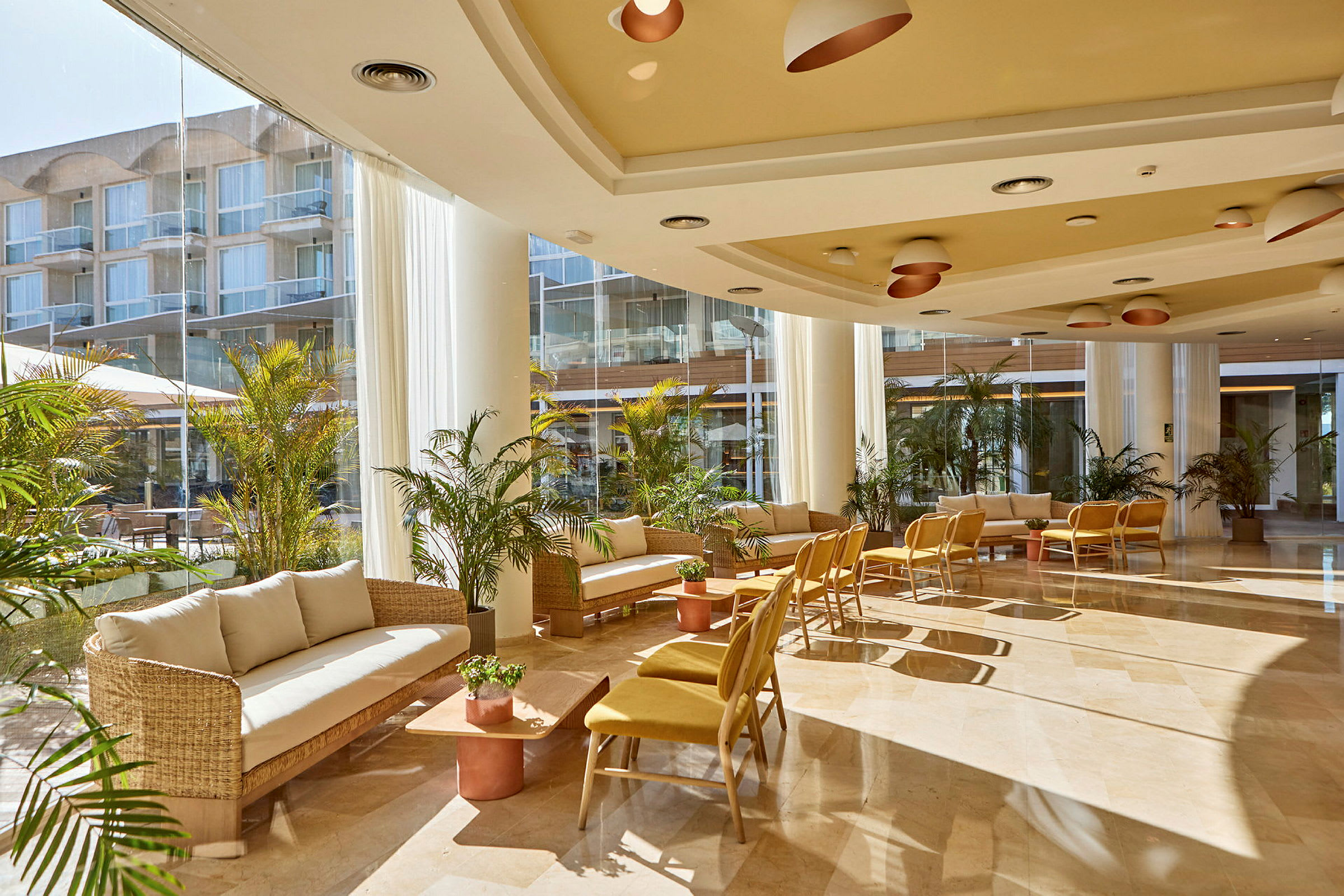 Interiør av en lys og moderne hotellobby med sittemøbler og planter. (AI-generert tekst)