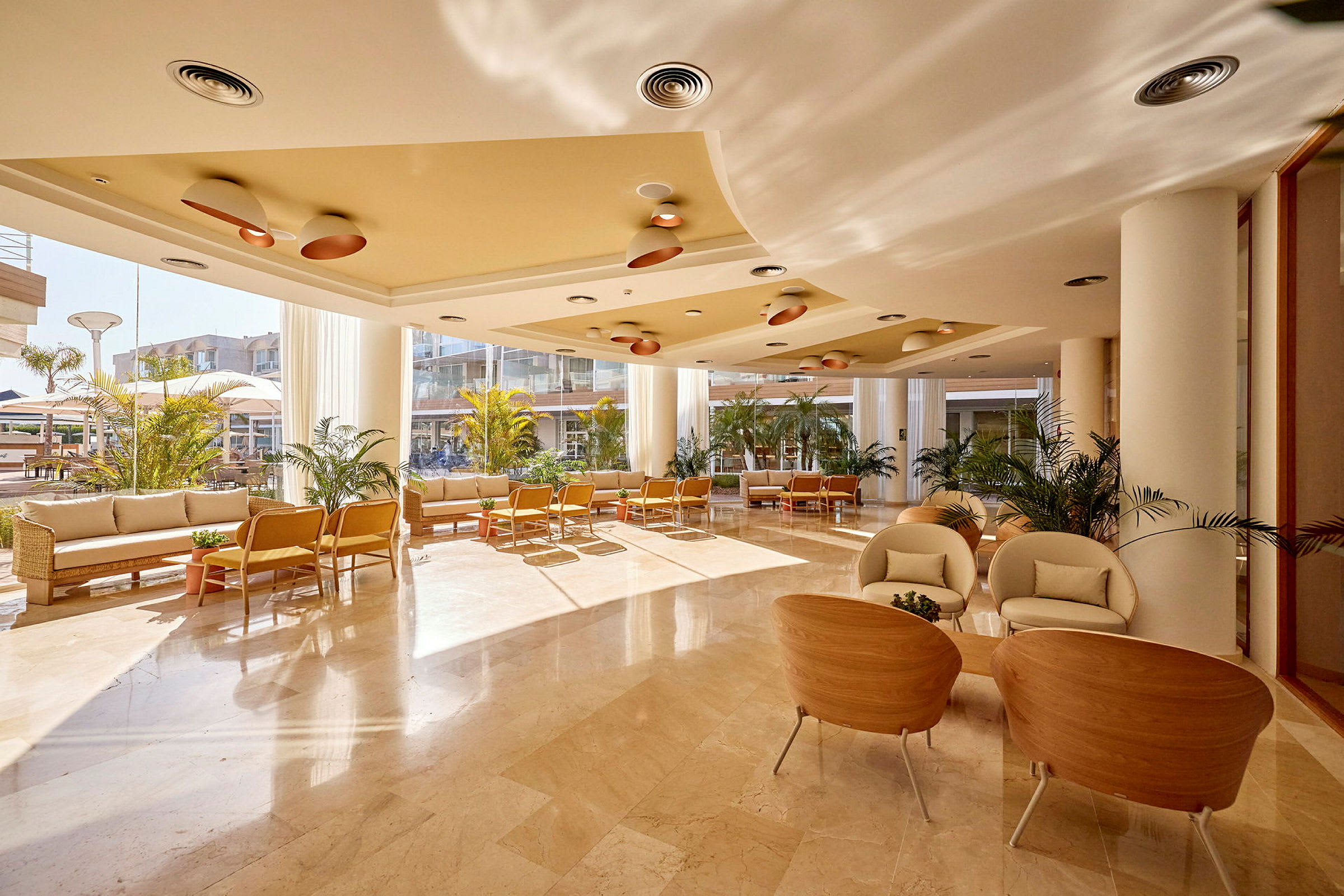 En lys og moderne hotellobby med sittemøbler og dekorative planter. (AI-generert tekst)