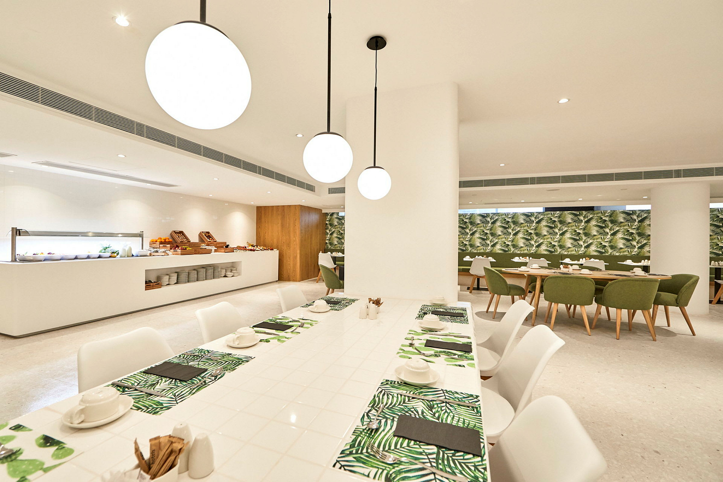 En stilren restaurant med hvite møbler og grønne detaljer. (AI-generert tekst)