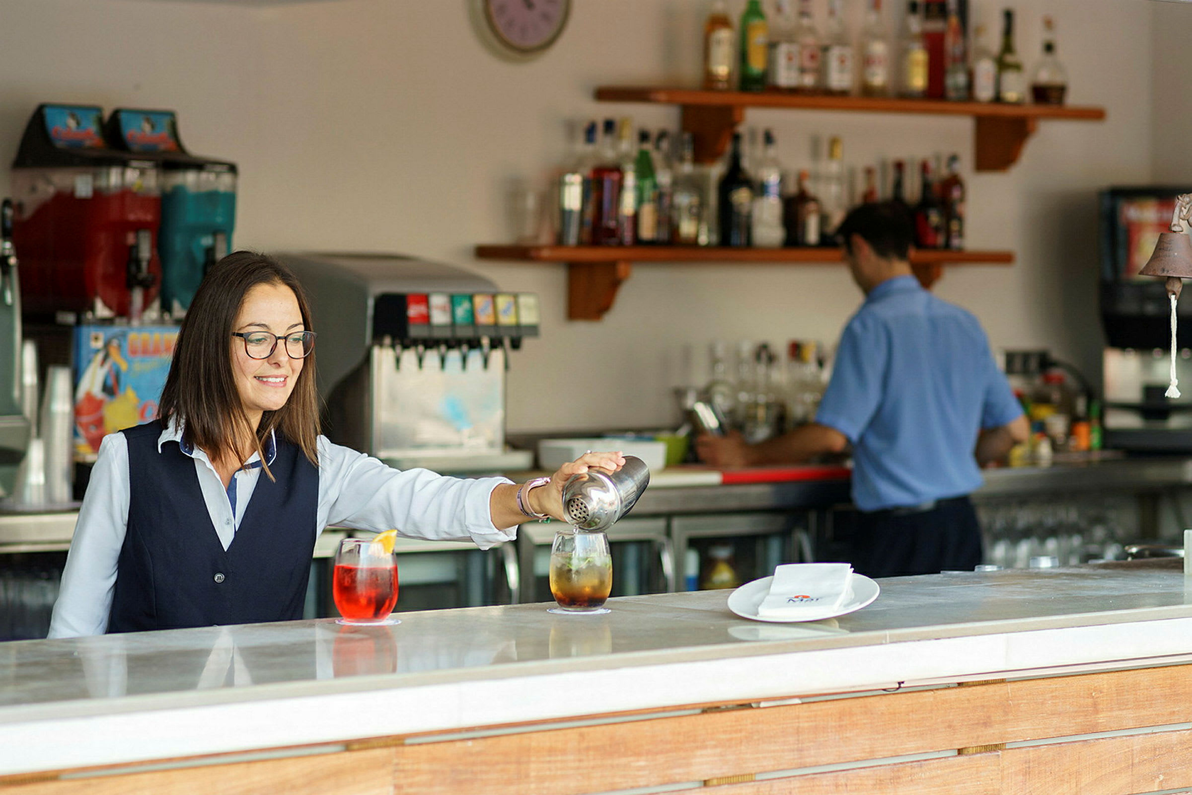 En bartender som heller drinker ved en bardisk. (AI-generert tekst)