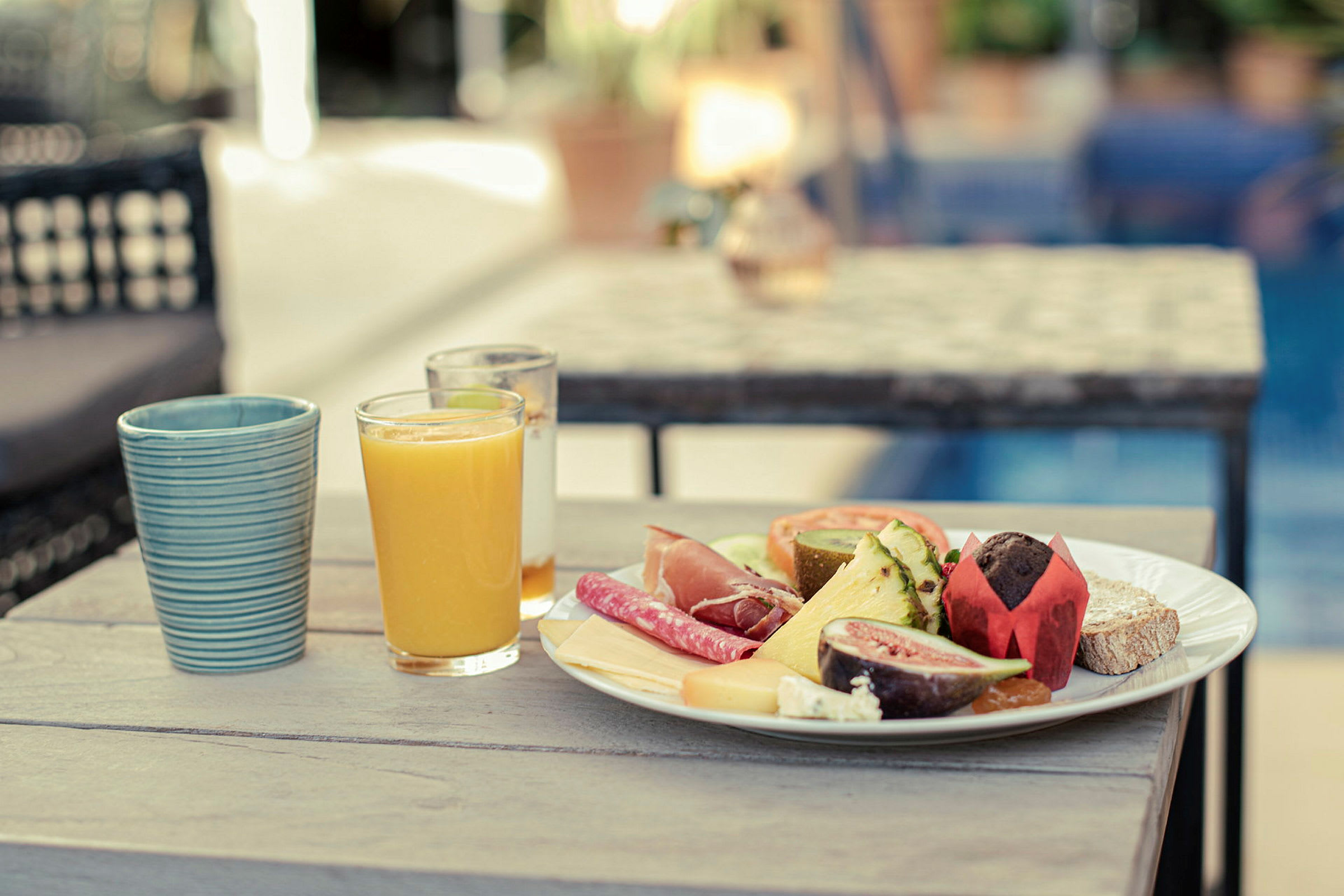 Frokostbord med et glass appelsinjuice og en tallerken fylt med forskjellige matvarer. (AI-generert tekst)