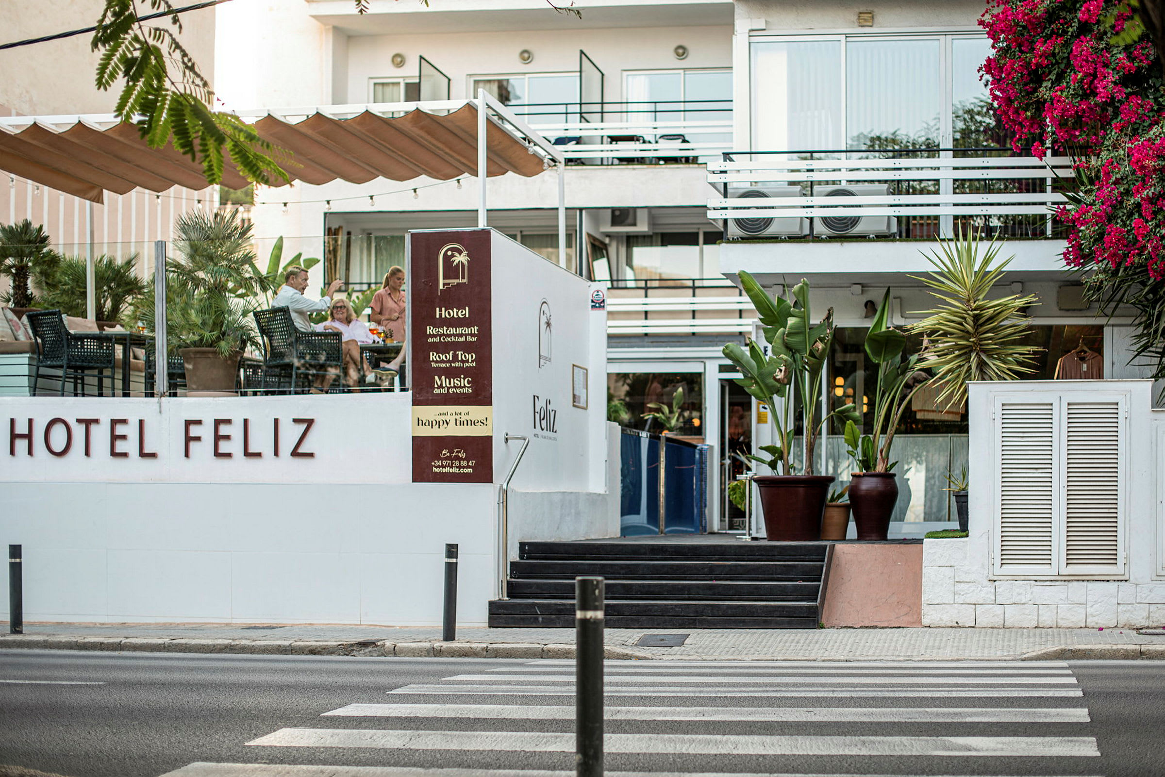Hotel Feliz med uteservering og blomstrende vegetasjon. (AI-generert tekst)