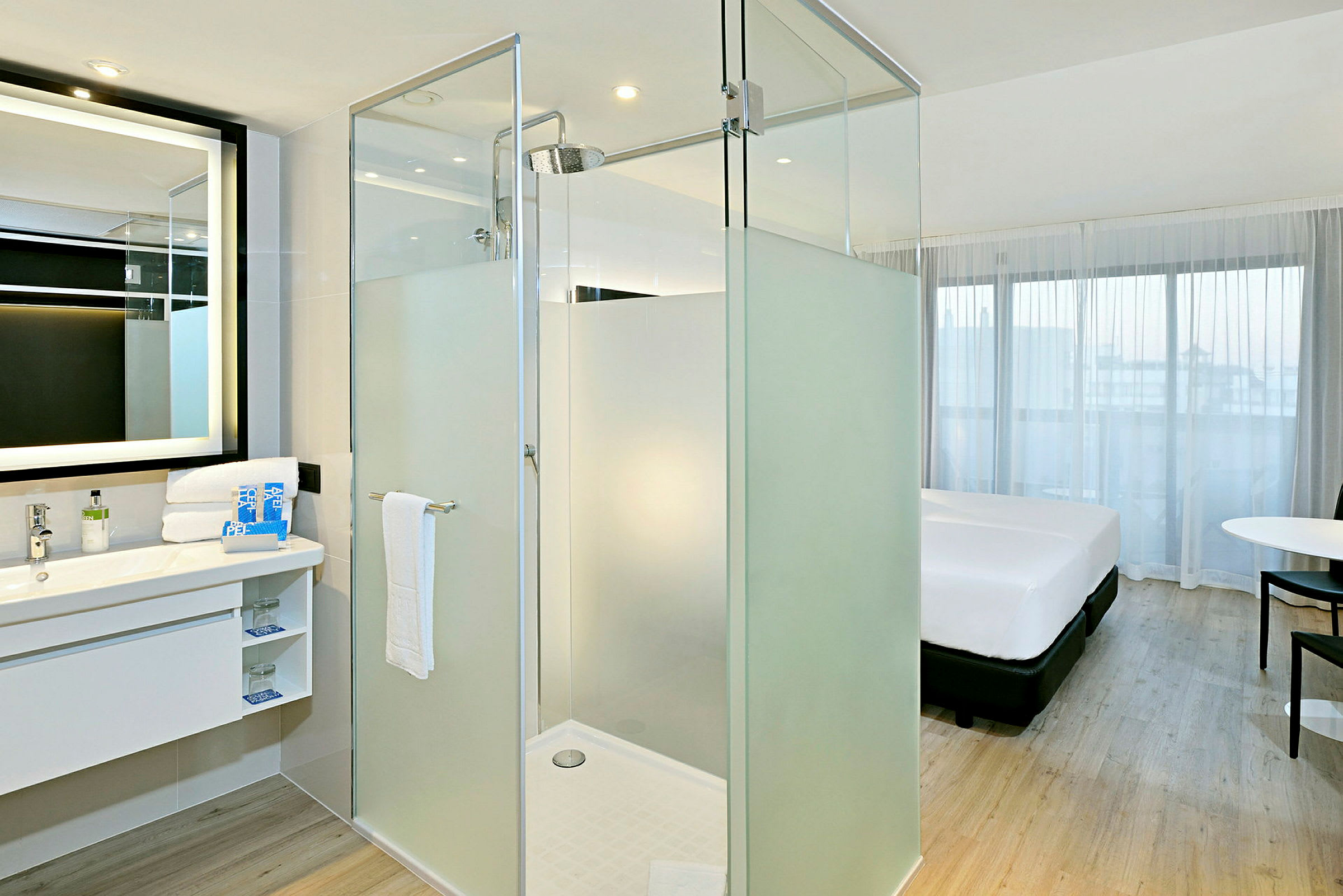 Et moderne hotellrom med dusjkabin og en seng. (AI-generert tekst)