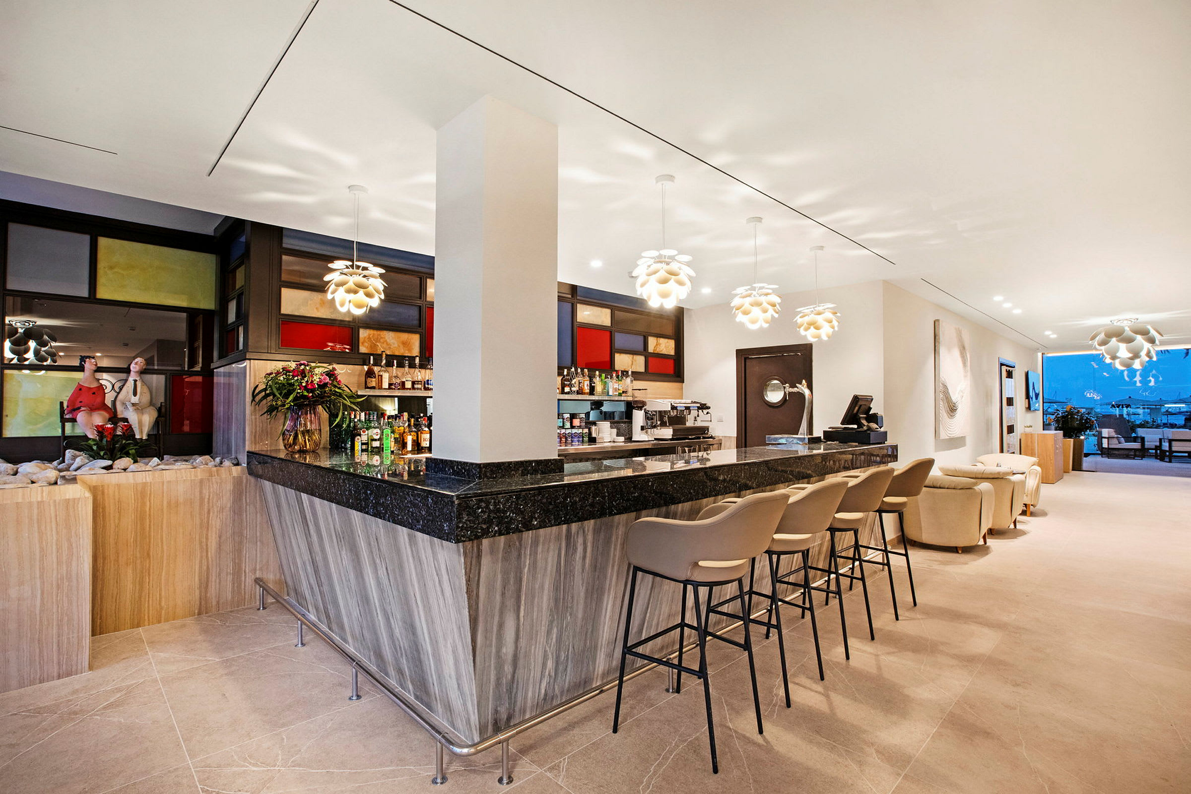 En moderne bar med svart og tremateriale, barstoler, dekorative lamper og utsikt over en terrasse med møbler i bakgrunnen. (AI-generert tekst)