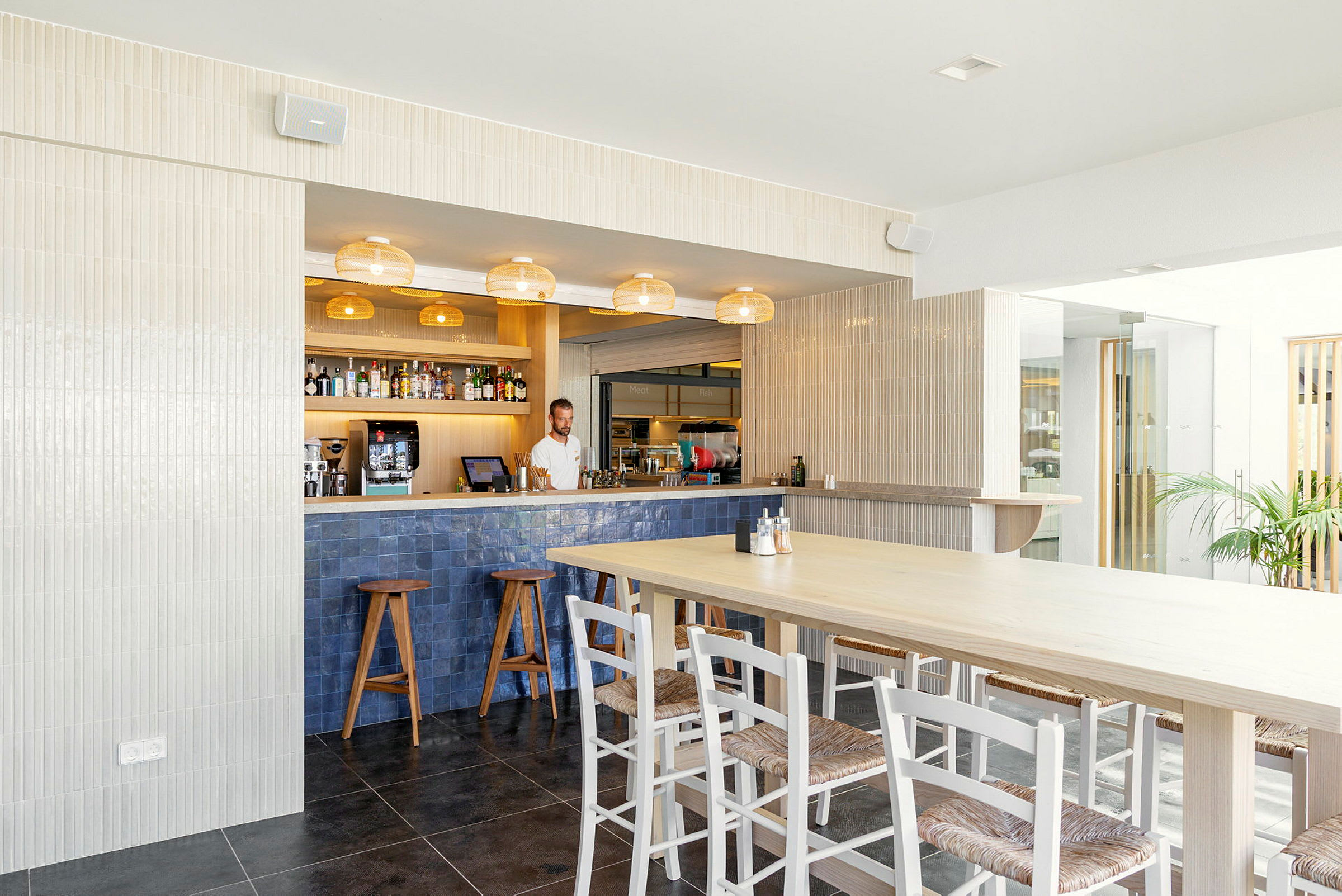 En moderne kafé med en bardisk, trestoler og et bord. (AI-generert tekst)