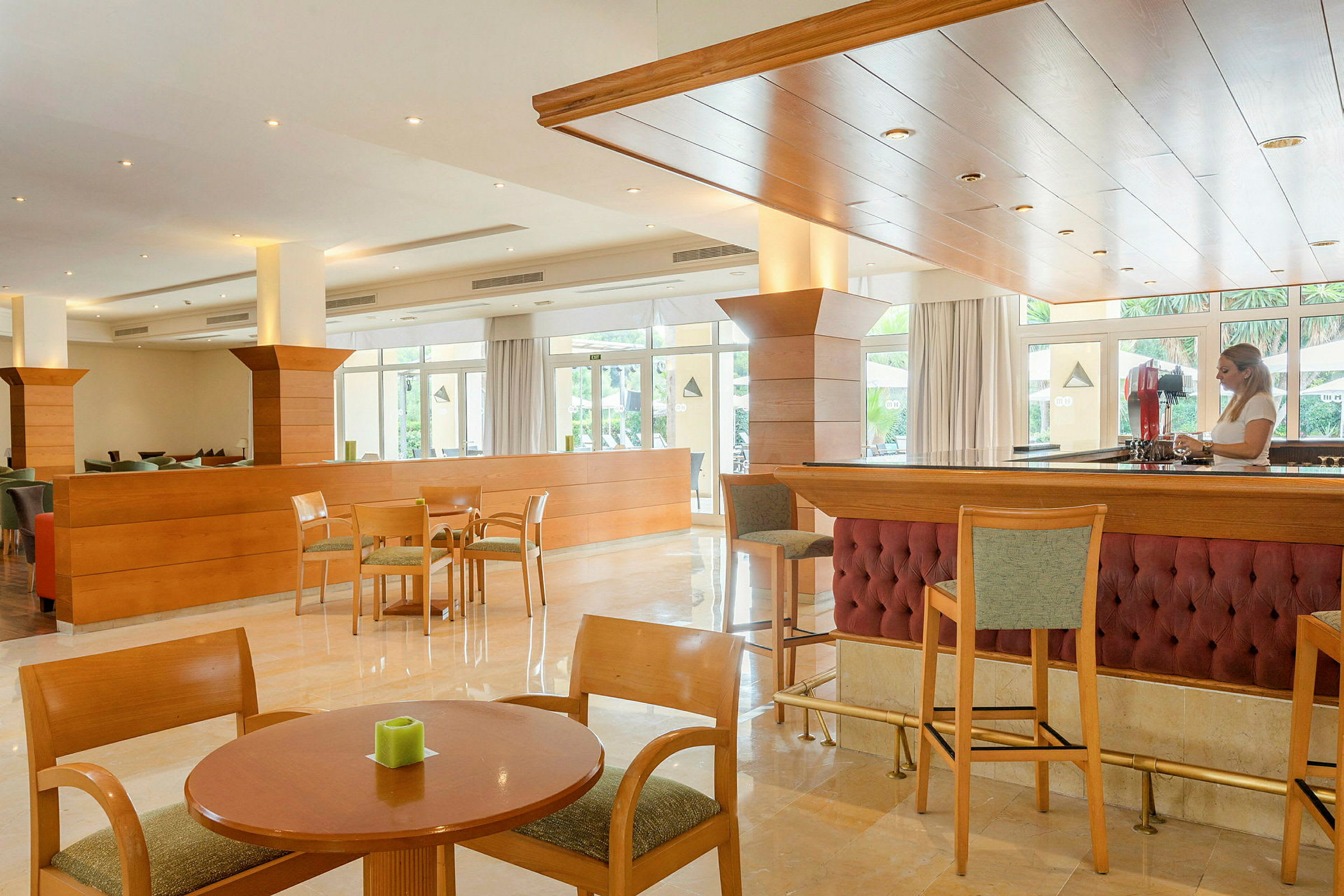 Interiør av en hotellbar og lounge med tremøbler og sittegrupper. (AI-generert tekst)