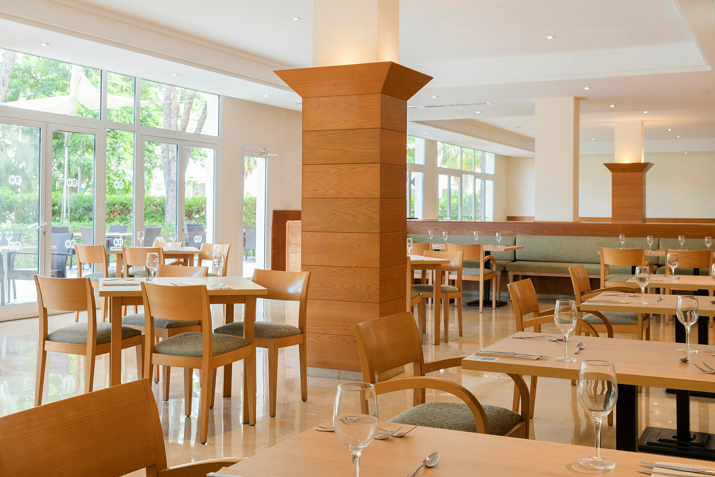 Lyse restaurantmøbler med glassvegger og tredetaljer. (AI-generert tekst)