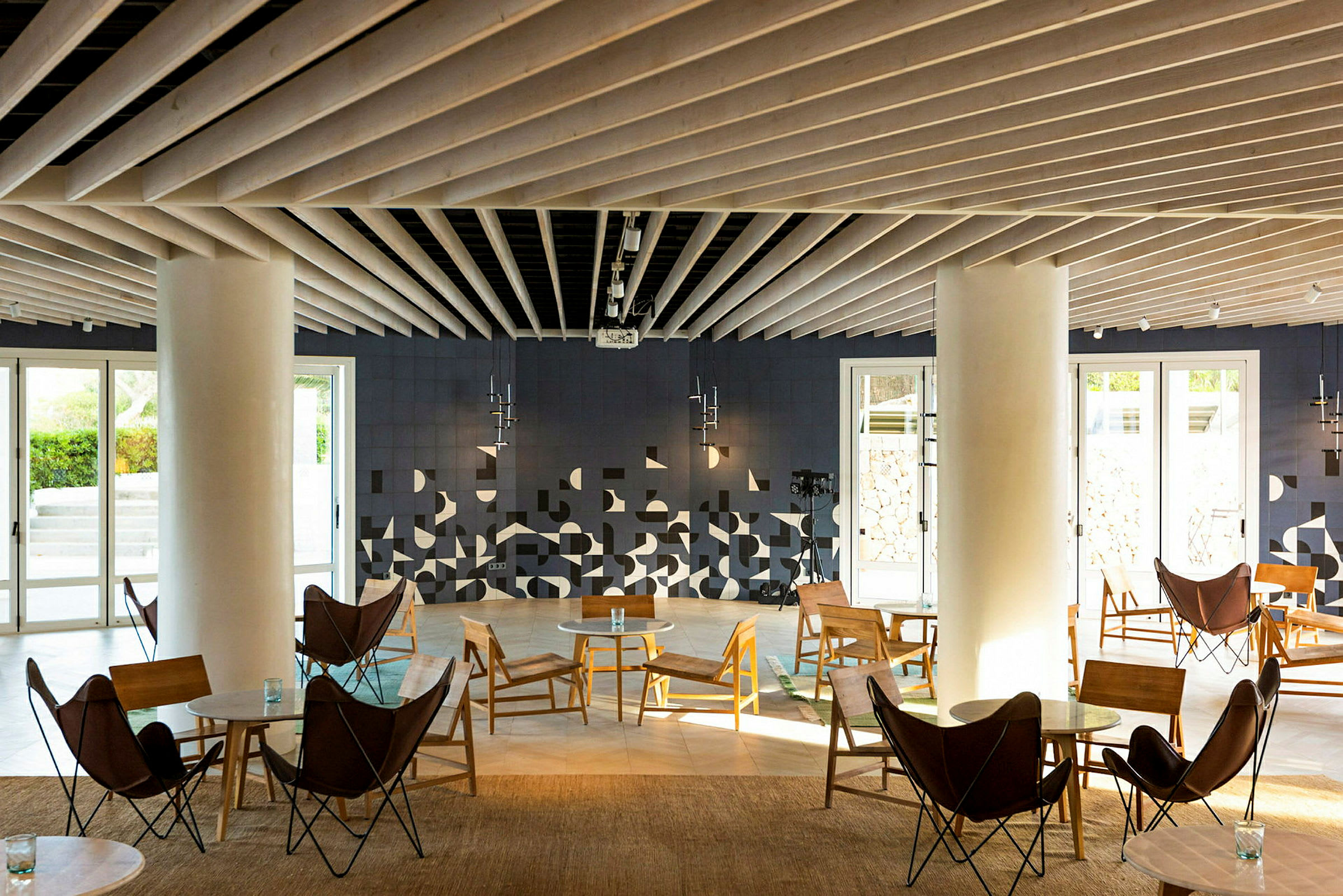 En moderne lounge med sittemøbler og geometriske dekorasjoner på veggen. (AI-generert tekst)