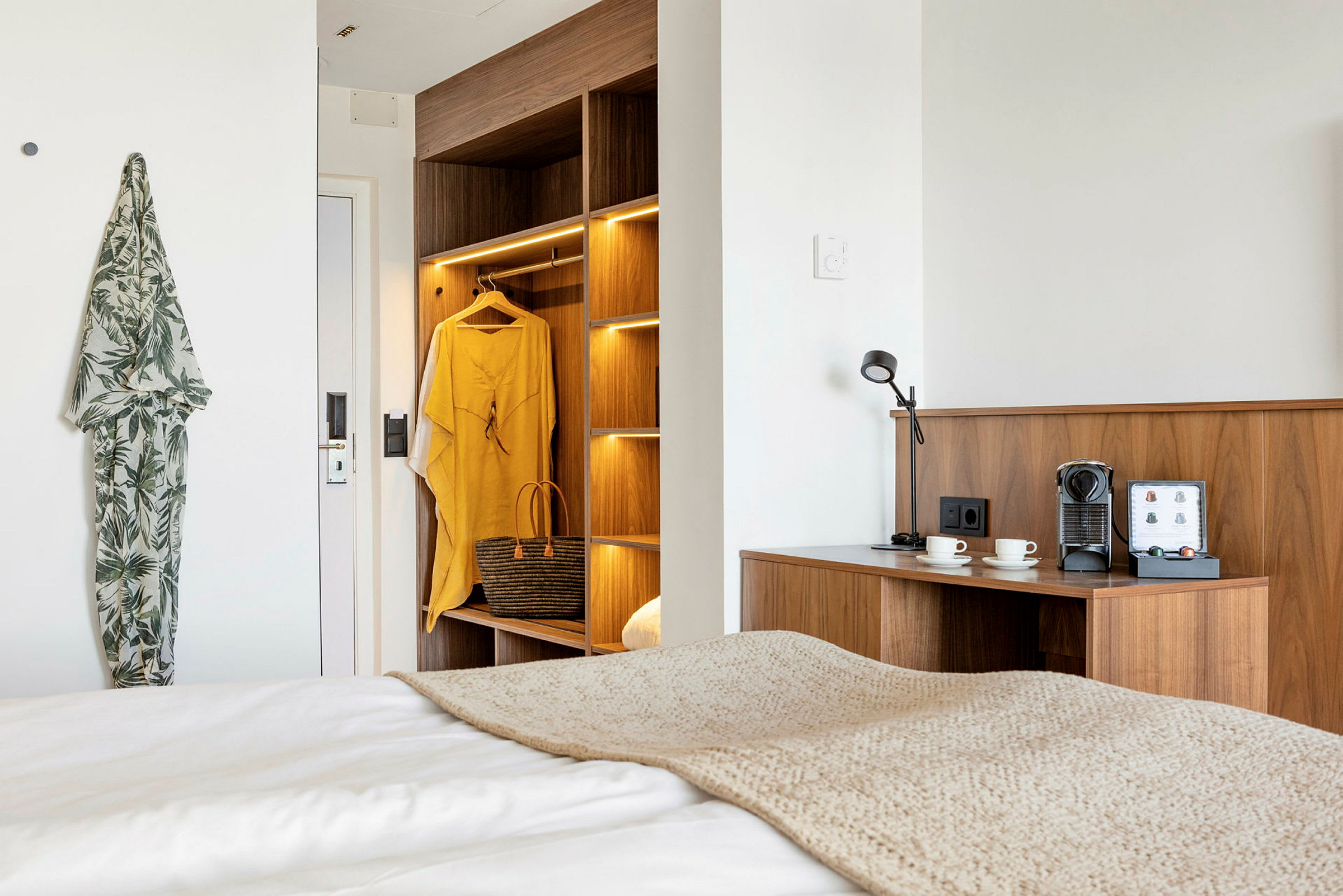 Moderne hotellrom med treinnredning, kaffestasjon og belysning. (AI-generert tekst)