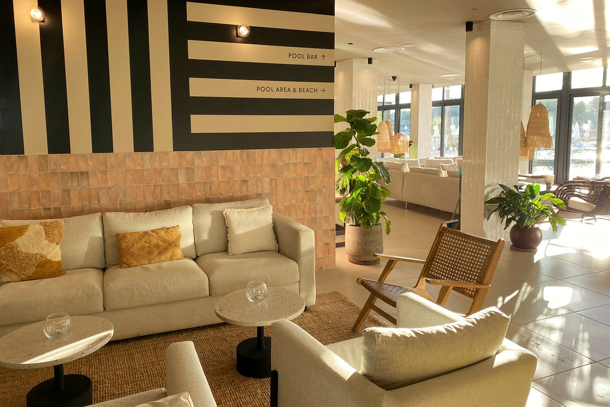 Bilde av en lys og moderne lobby med sofagruppe og grønne planter. (AI-generert tekst)
