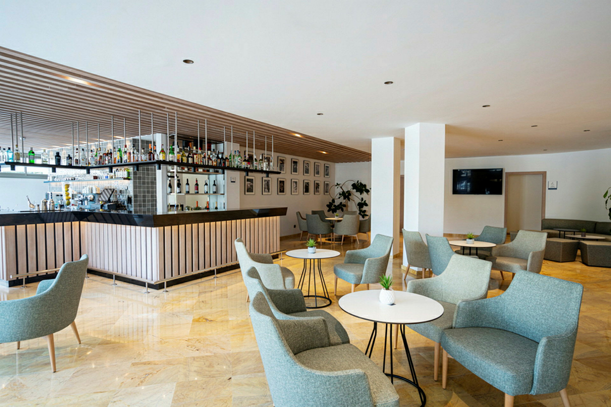 Interiør av en moderne bar med sitteplasser og bord. (AI-generert tekst)