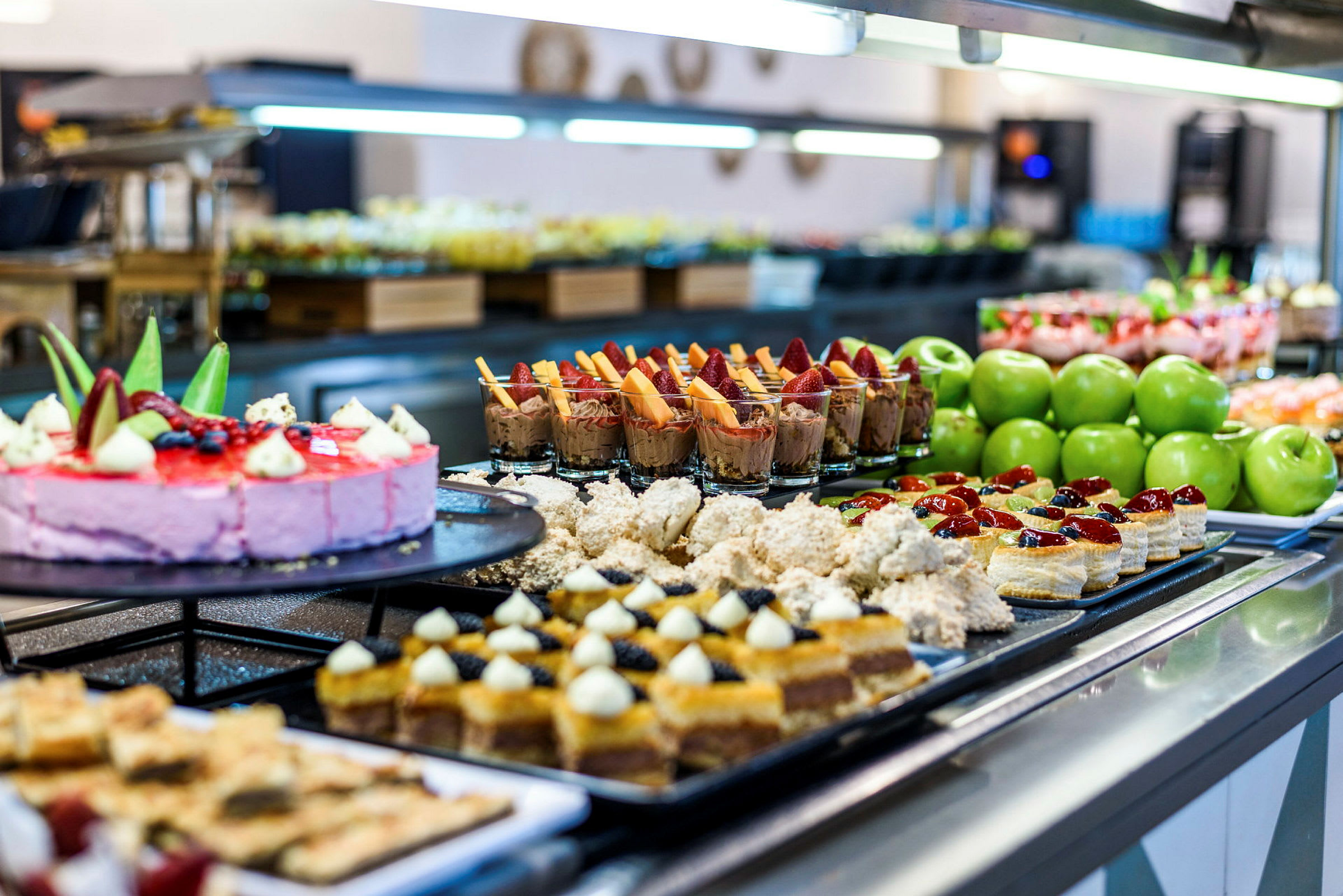 Buffé med forskjellige desserter, kaker og grønne epler. (AI-generert tekst)