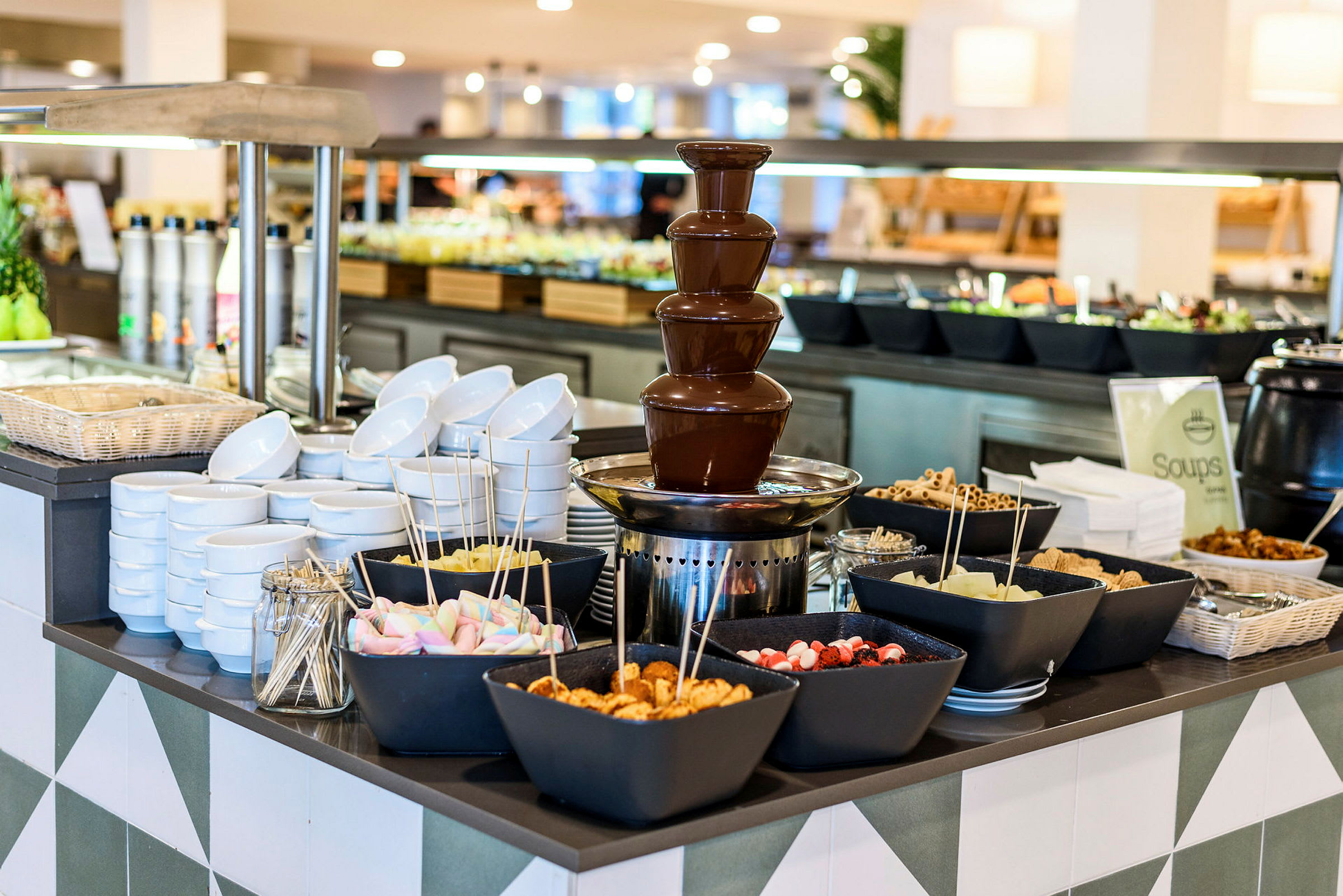 En buffet med en sjokoladefontene og boller fylt med forskjellige tilbehør. (AI-generert tekst)
