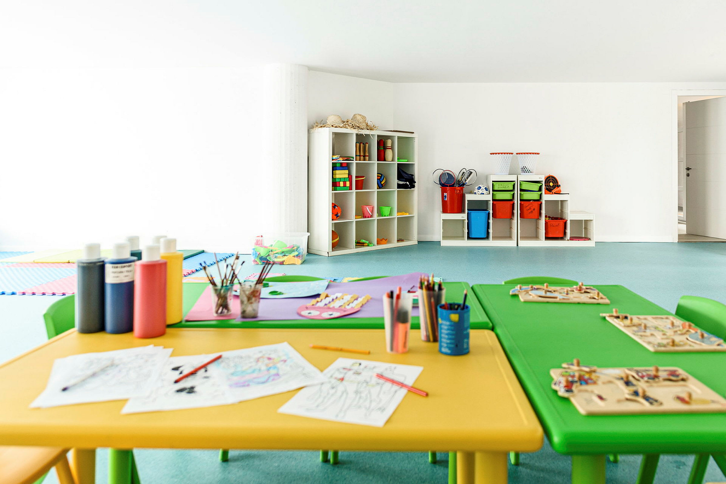 Et barnehobbyrom med bord, stoler og materialer for kreativ utfoldelse. (AI-generert tekst)