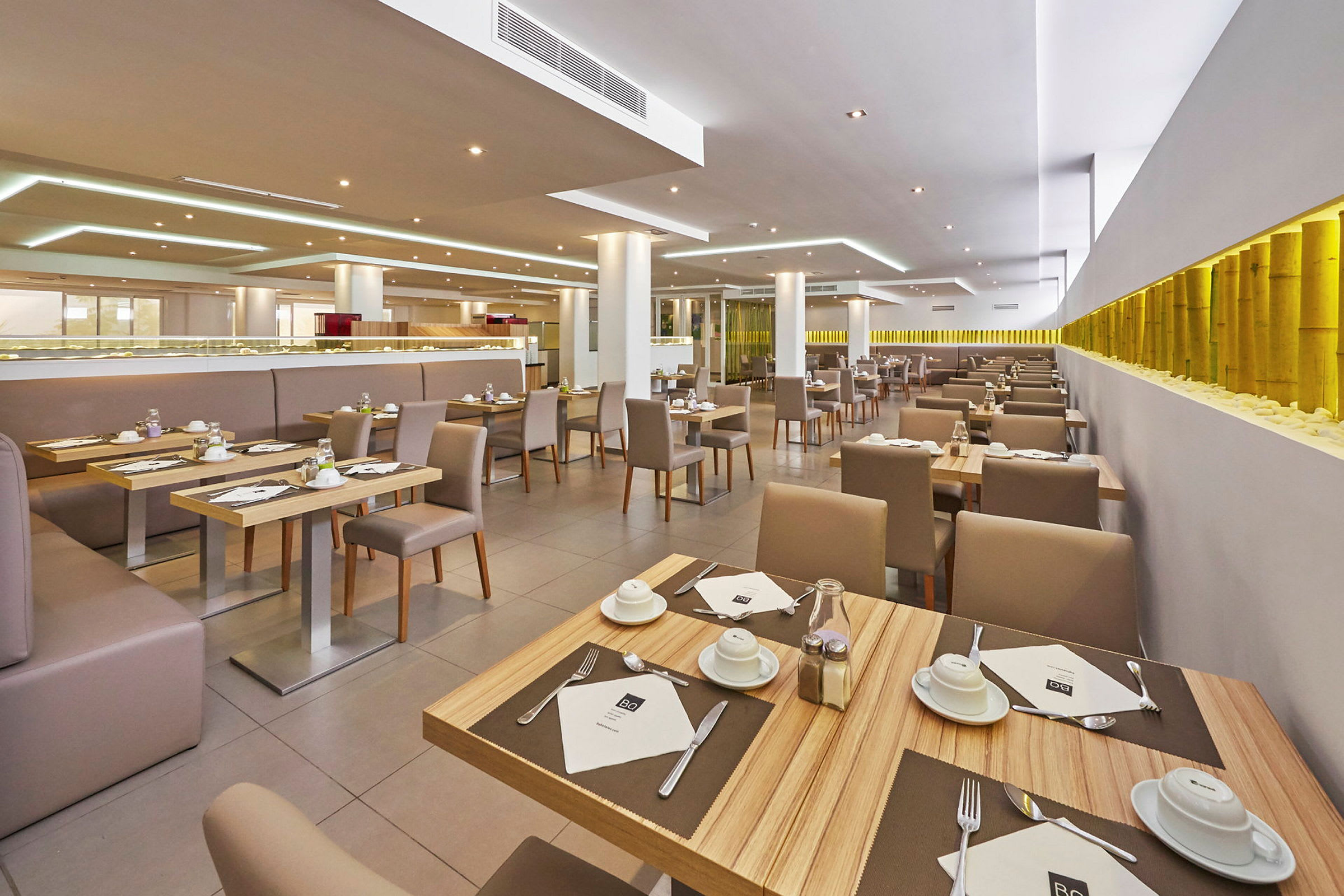 En moderne restaurant med dekkede bord og komfortable stoler. (AI-generert tekst)