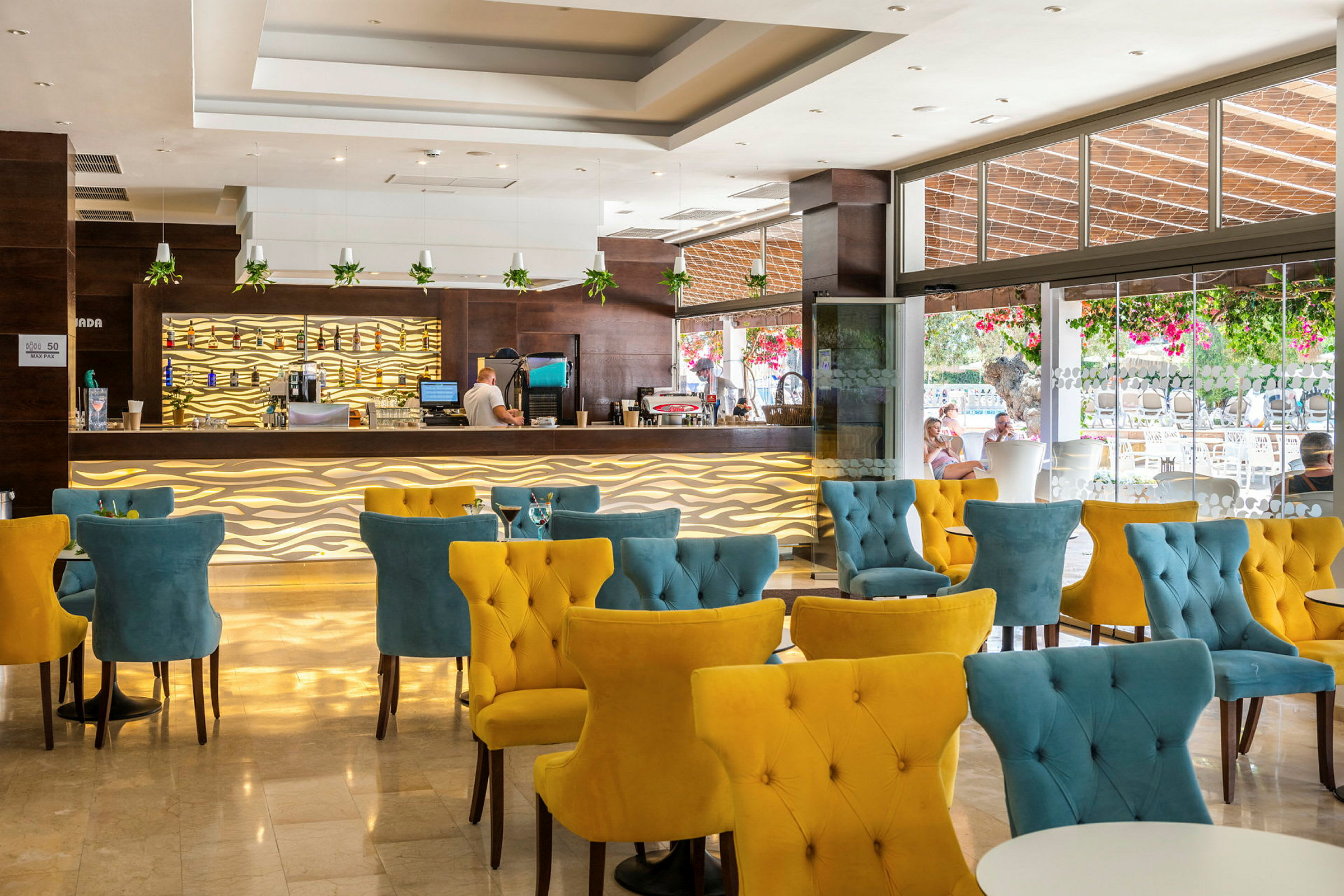 En moderne hotellbar med fargerike stoler og dekorative belysningsdetaljer. (AI-generert tekst)