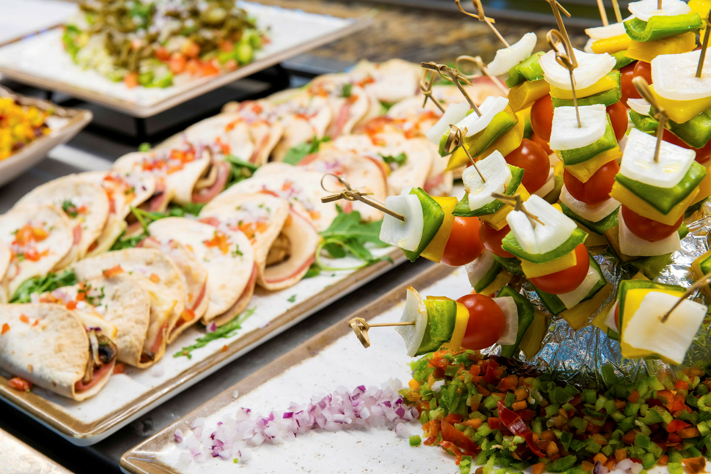Buffet med små tortillas og fargerike grønnsaksspyd. (AI-generert tekst)
