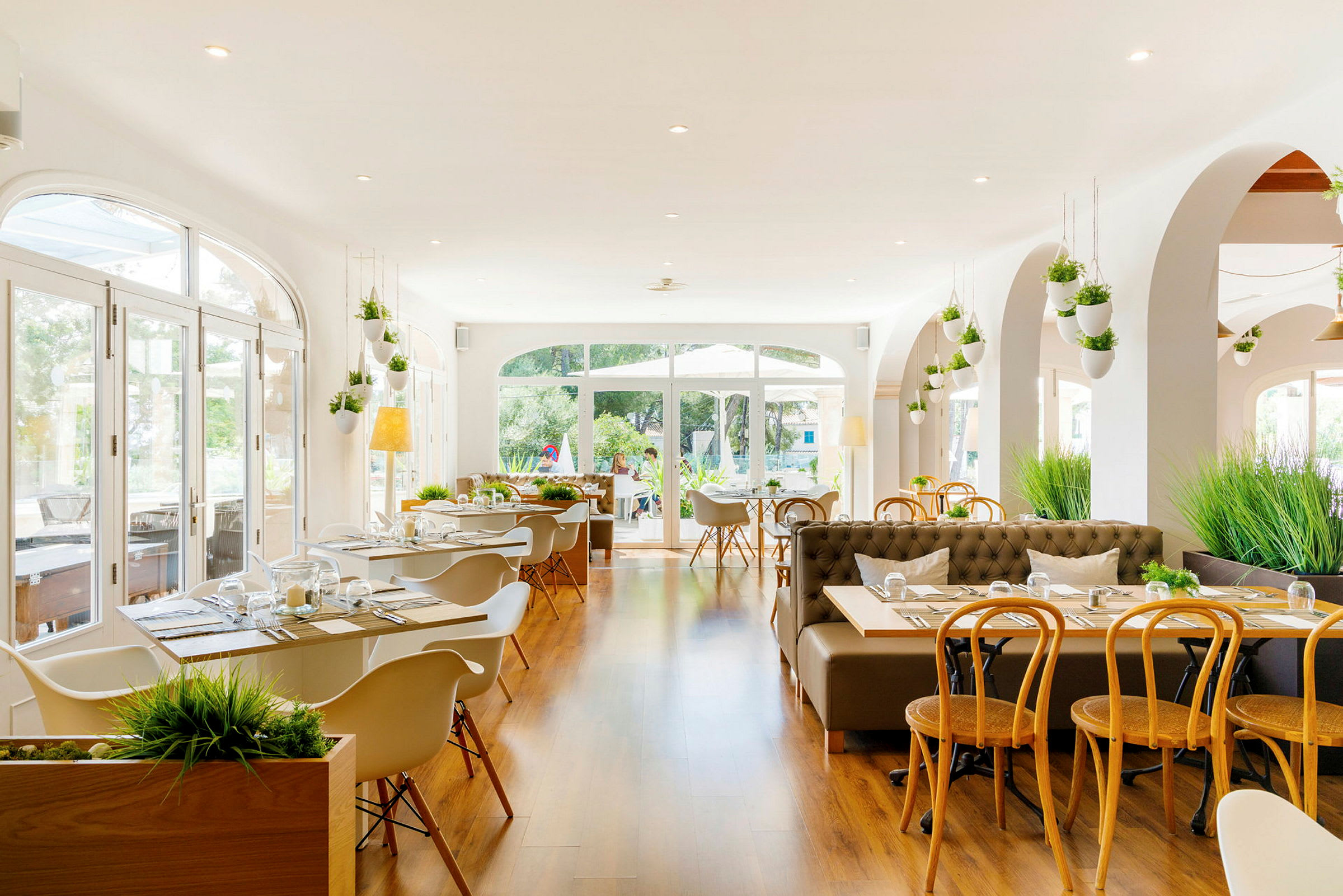 En lys og moderne restaurant med store vinduer og treinnredning. (AI-generert tekst)