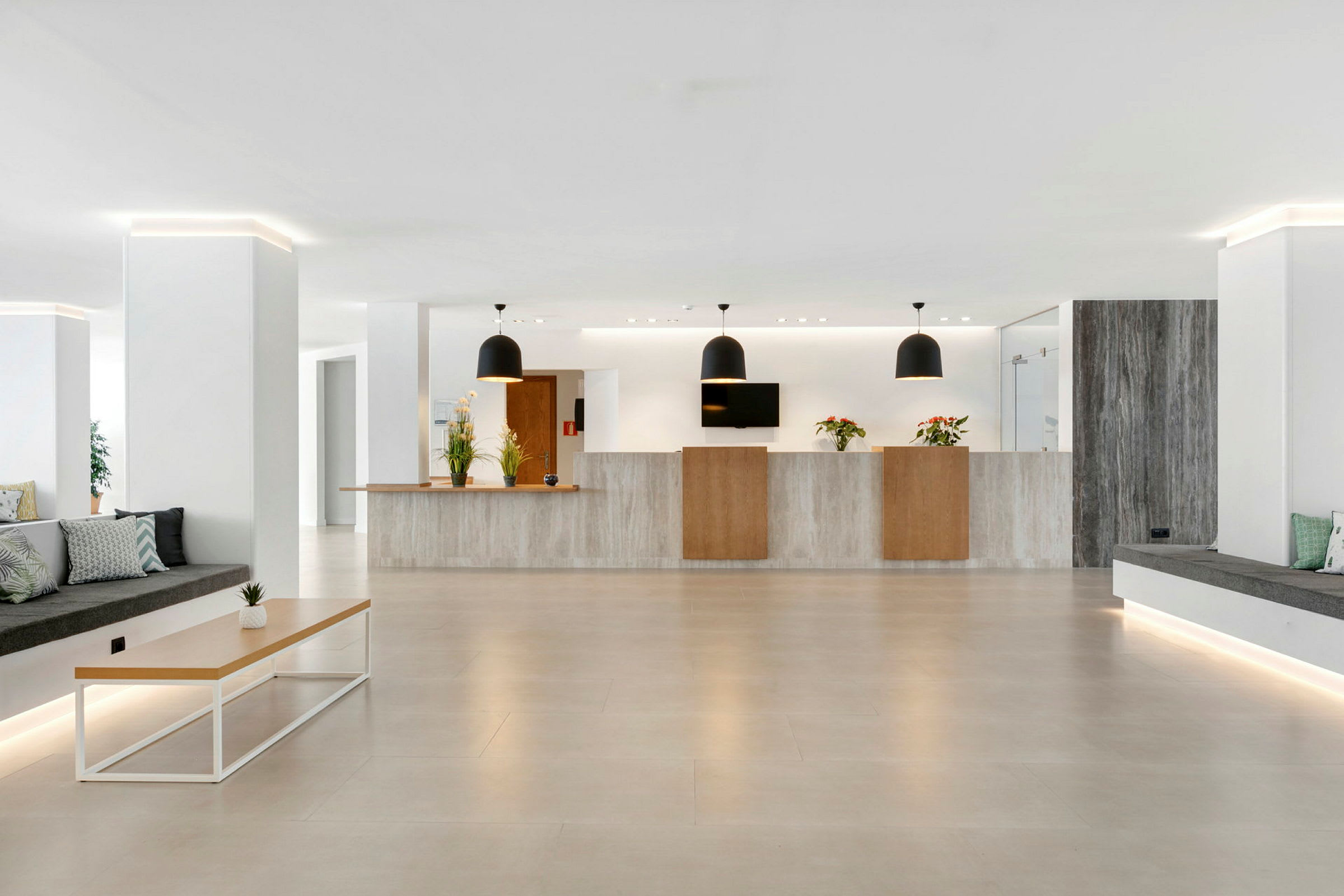 Hotellobby med resepsjonsdisk, moderne møbler og planter. (AI-generert tekst)