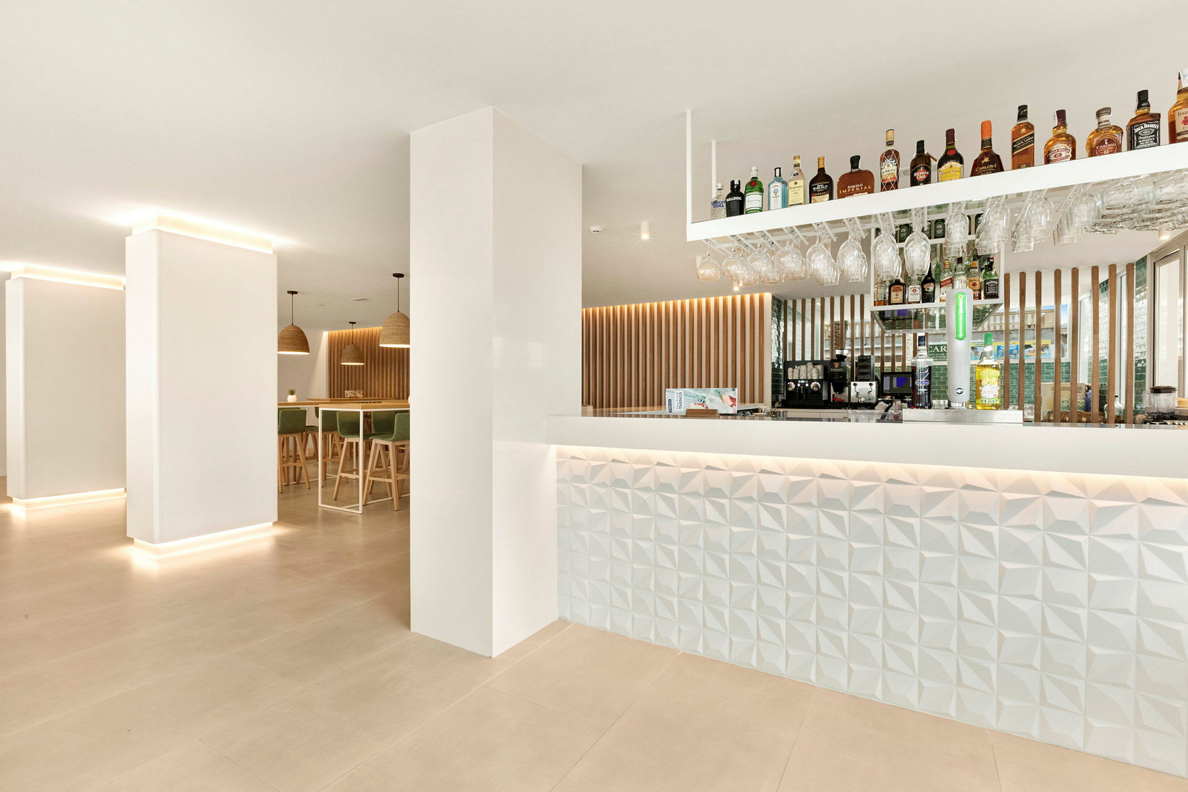 Moderne innredet hotellbar med opplyst disk og hyller med drikke. (AI-generert tekst)