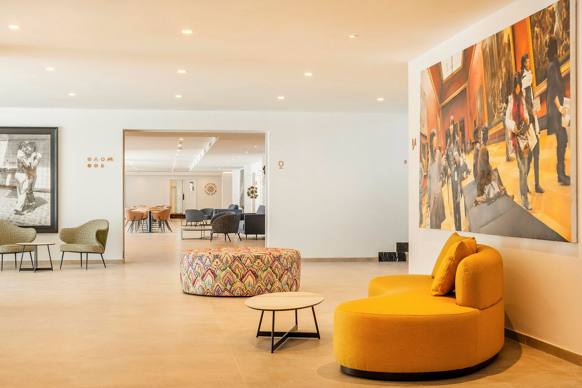 En moderne lounge med sittemøbler, en fargerik rund ottoman og et stort kunstverk på veggen. (AI-generert tekst)