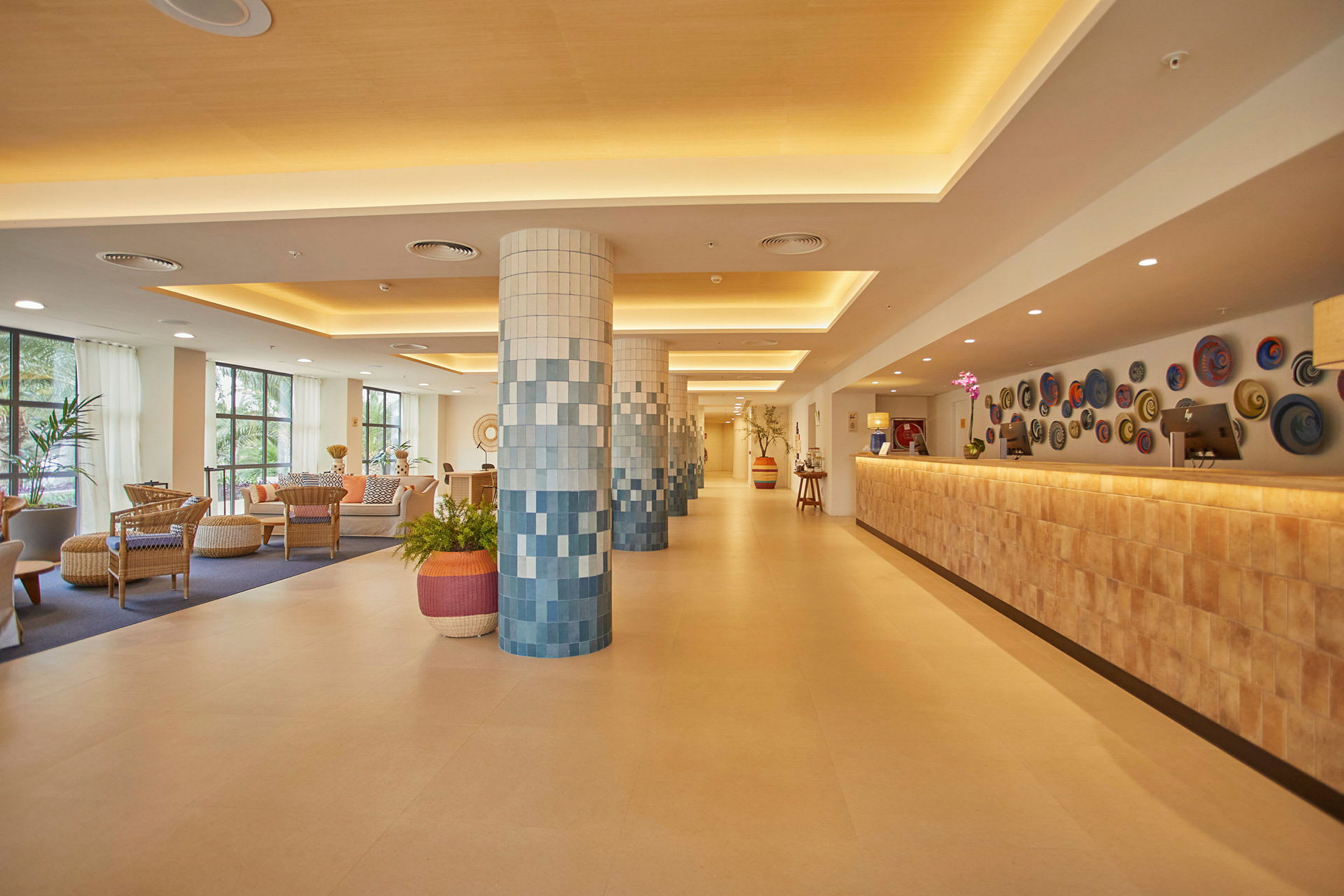 Hotellobby med sittegrupper, dekorerte søyler og resepsjon. (AI-generert tekst)
