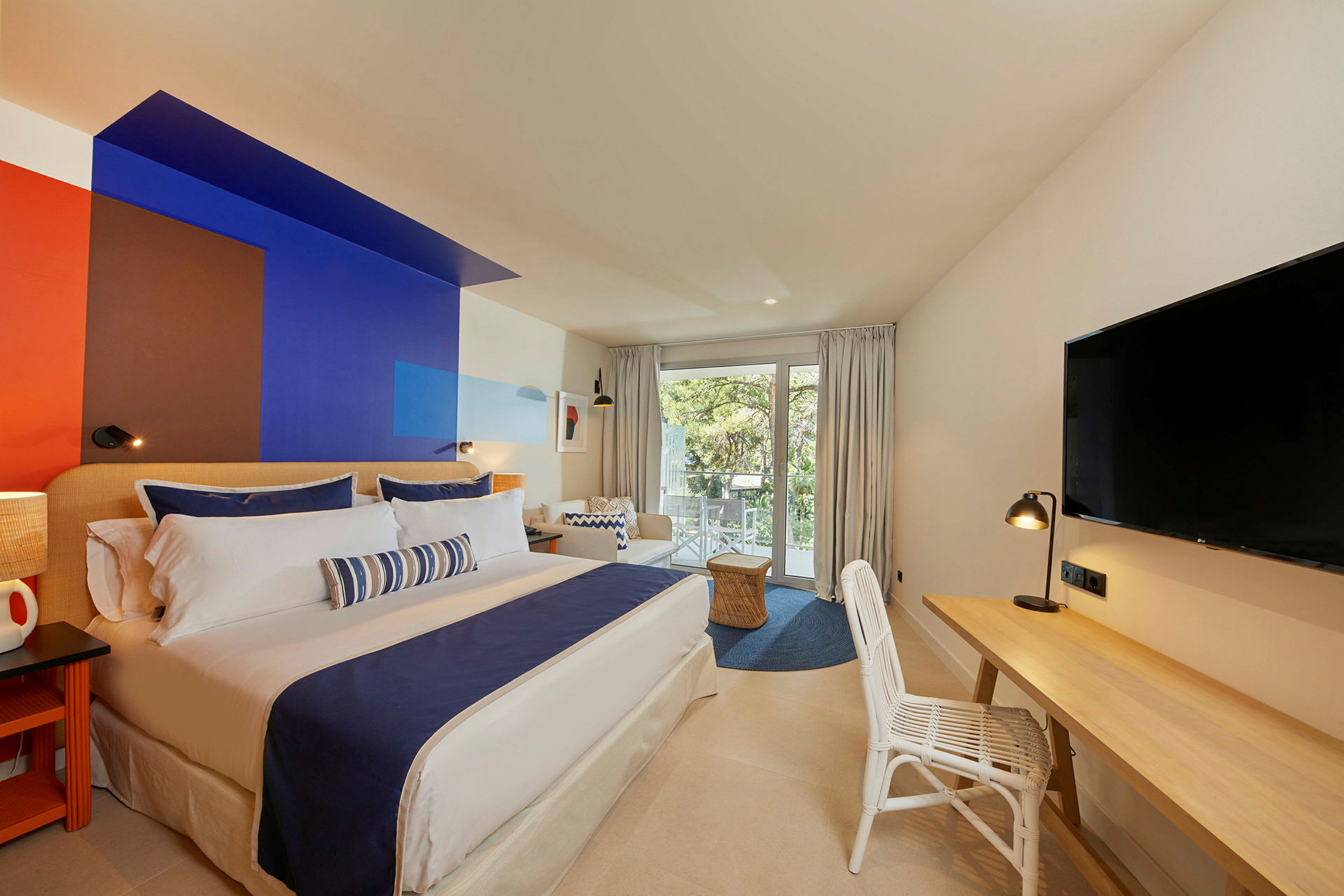 Moderne hotellrom med en stor dobbeltseng og en fargerik veggdesign. (AI-generert tekst)