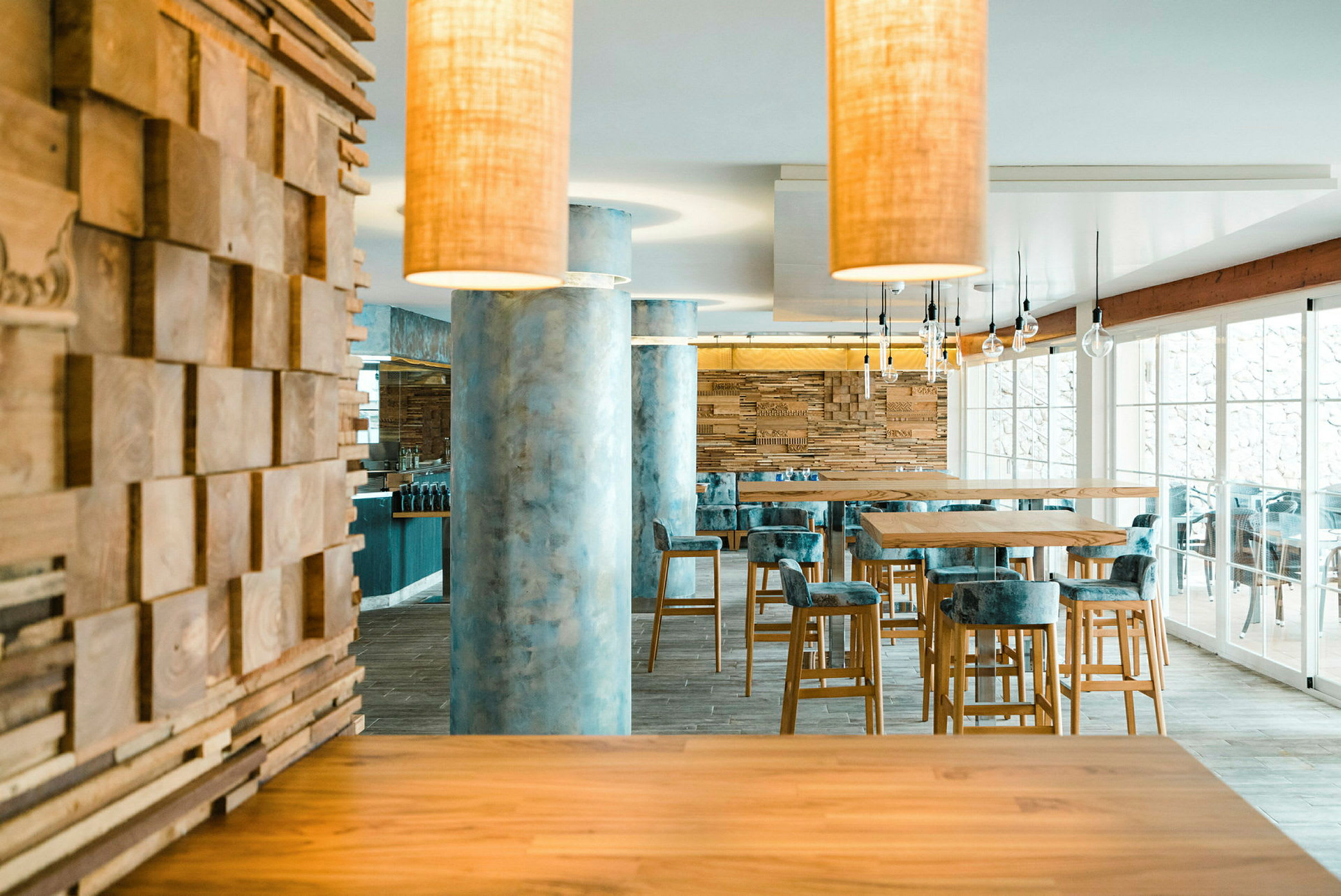 Moderne restaurantinteriør med tre og marmor samt høye bord og stoler. (AI-generert tekst)