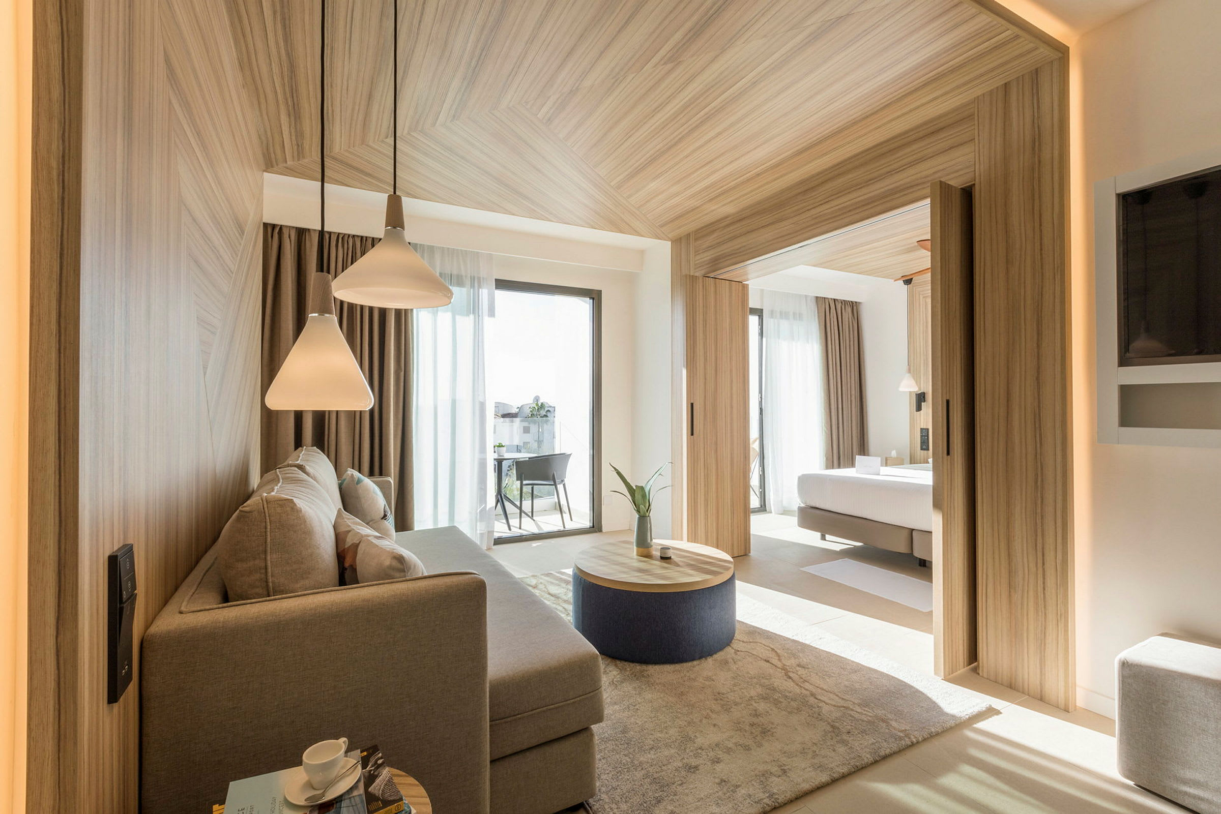 Et moderne hotellrom med separat soverom og sitteområde. Rommet har store vinduer og elegant interiør. (AI-generert tekst)