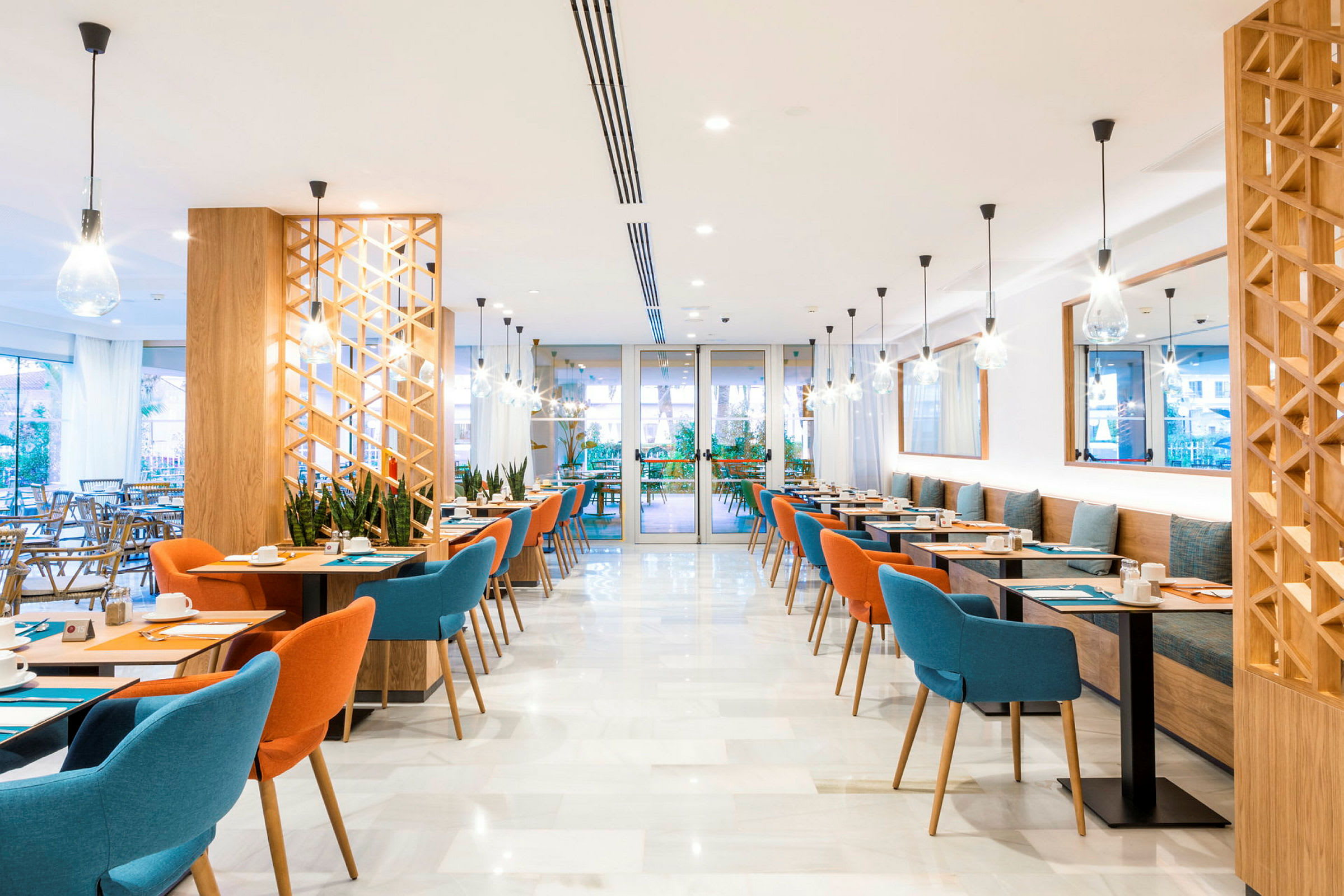 En moderne restaurant med fargerike stoler og elegant belysning. (AI-generert tekst)