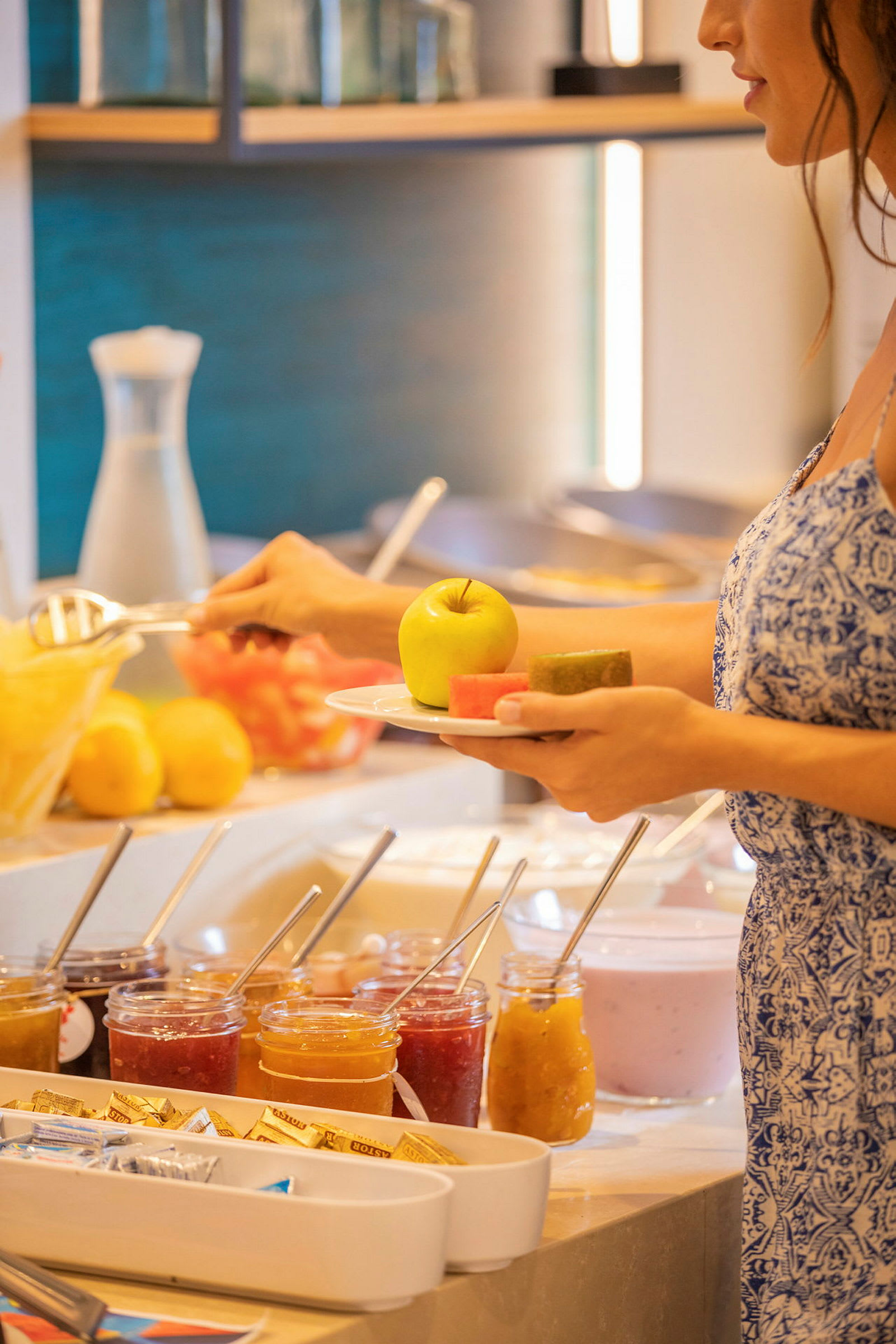 En person tar frukt og andre matvarer fra en buffet. (AI-generert tekst)