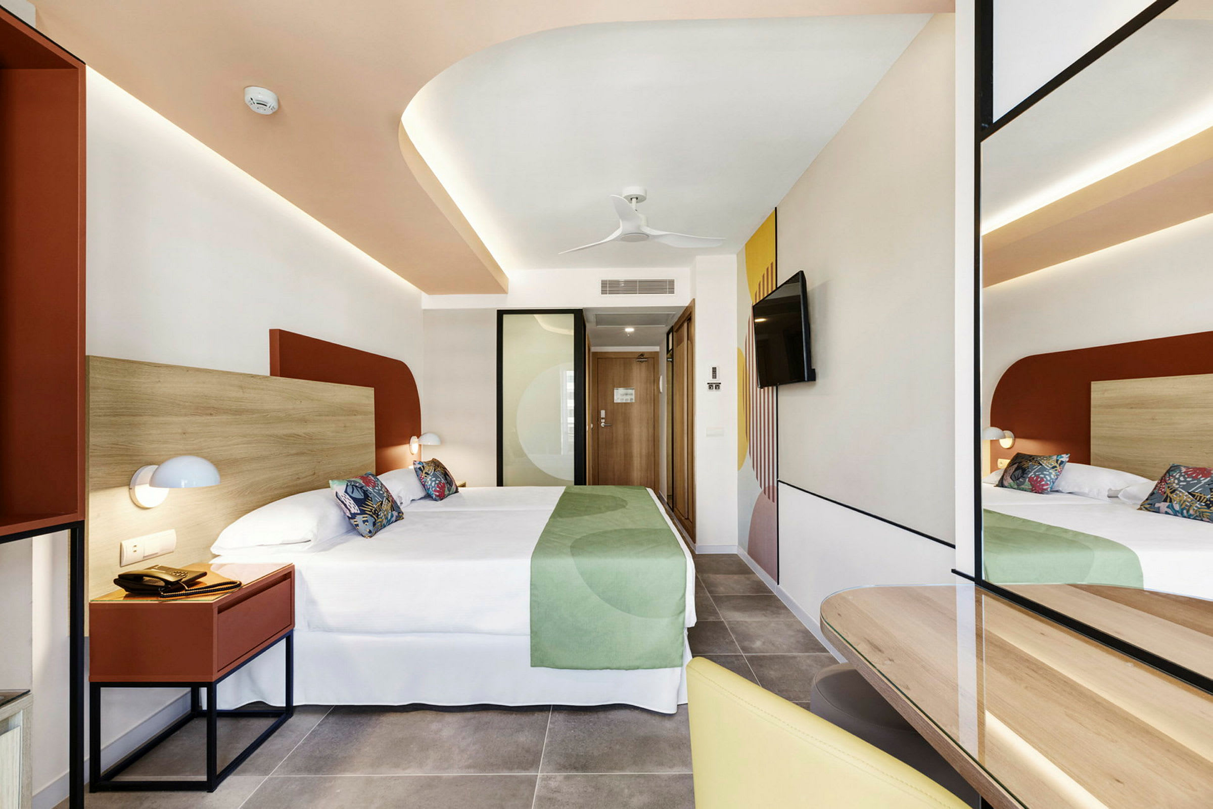 Hotellrom med moderne innredning, dobbeltseng og speil. (AI-generert tekst)